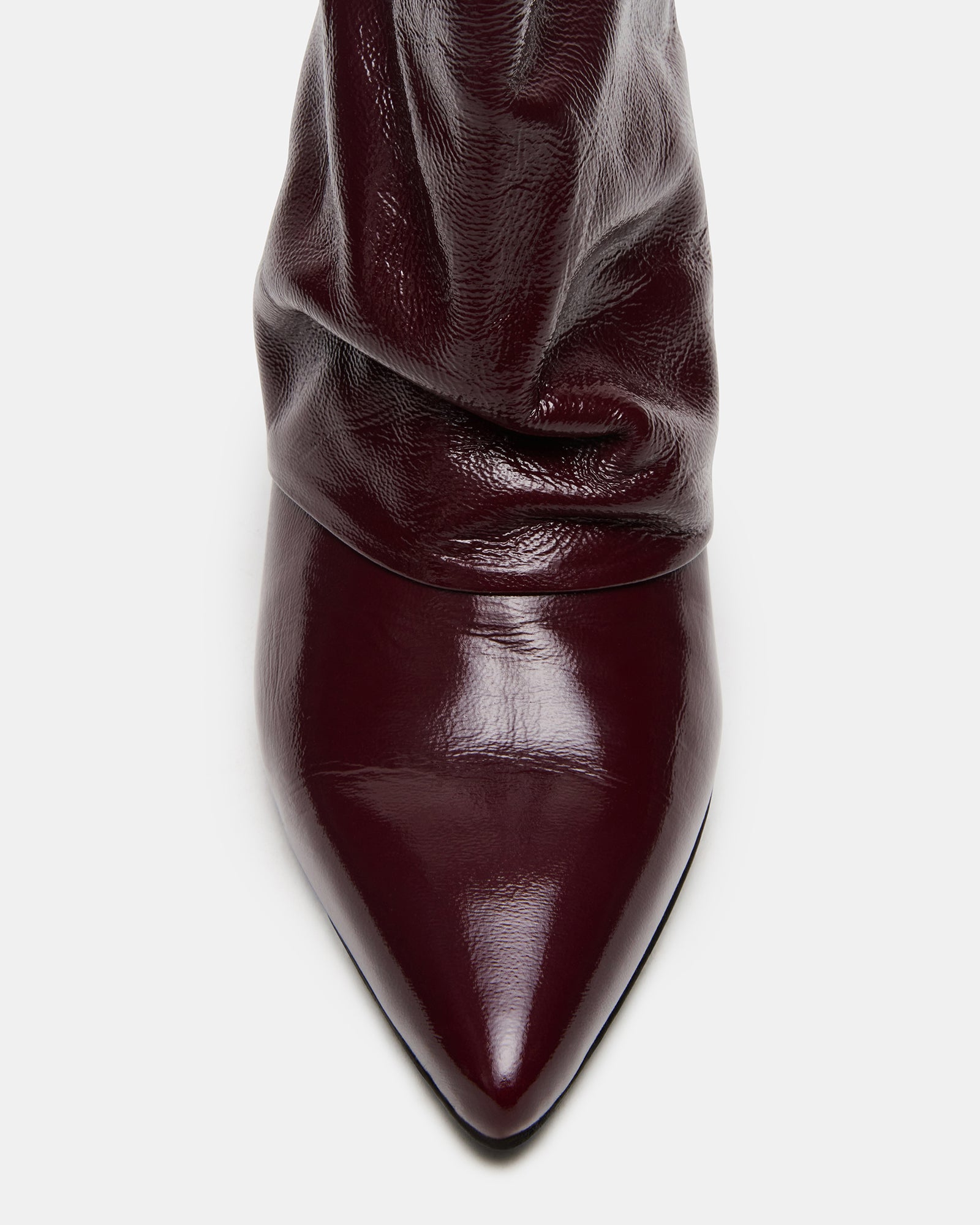 Side view of black kitten heel boots on a wooden floor
