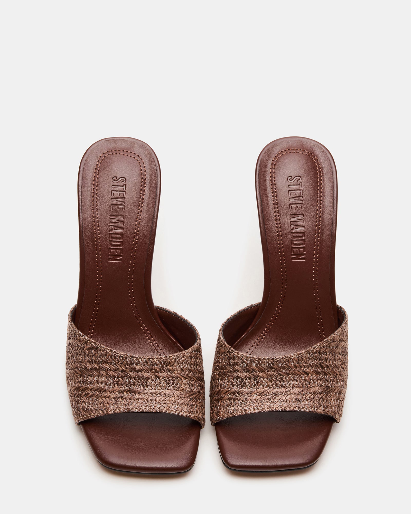 Sia Brown mules heels styled with jeans and a blazer for a chic daytime look.