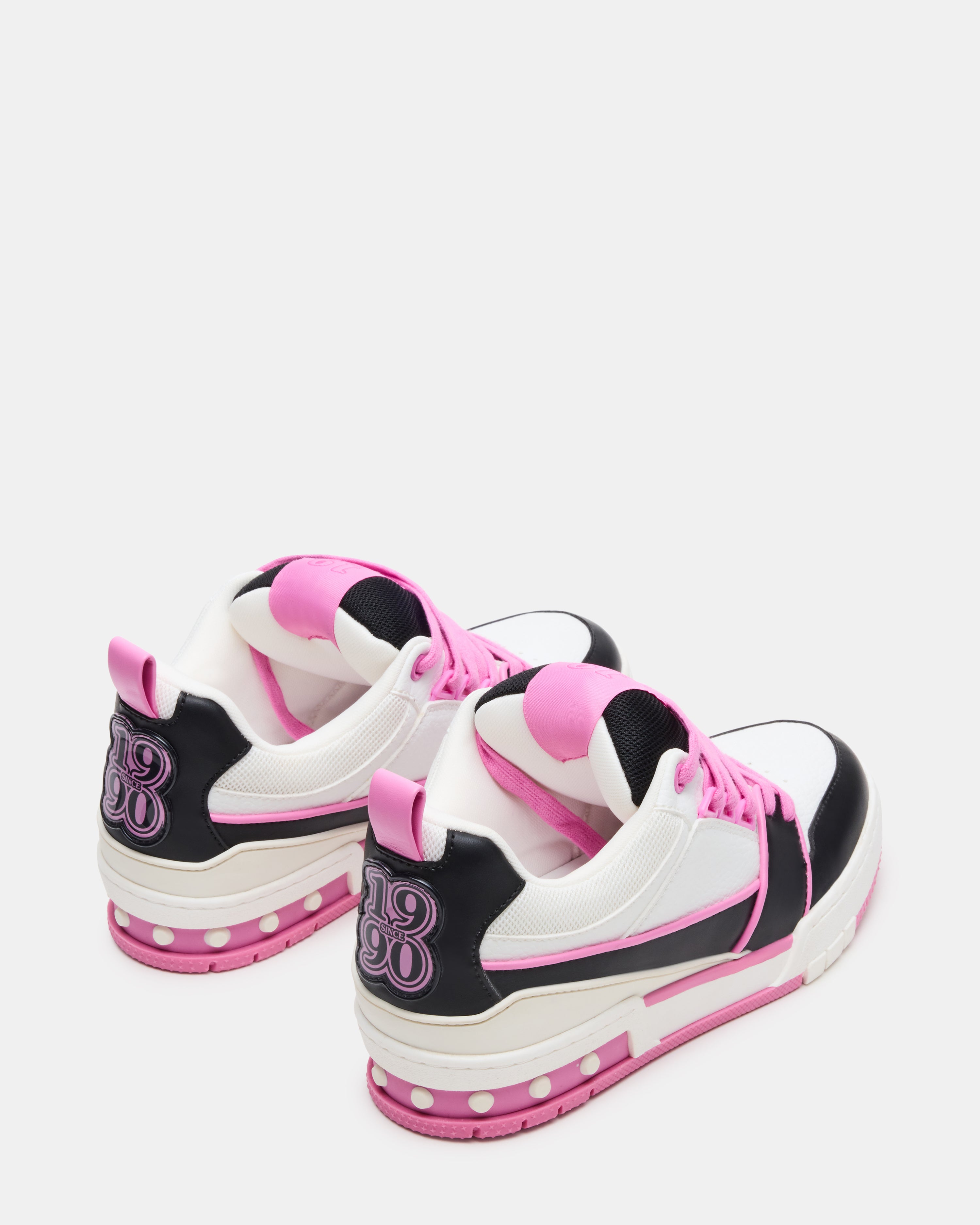 SKATER low-top sneakers on feet, showcasing the black and pink design