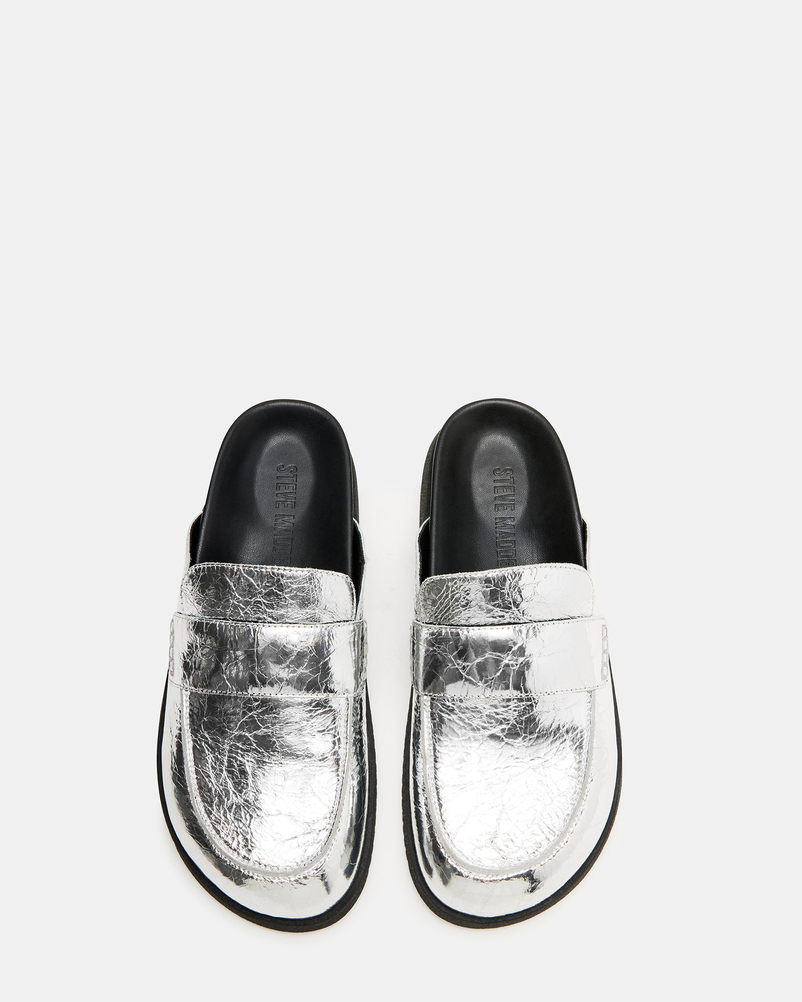 Skipper Silver Metallic Mules from the side, highlighting stitch details.