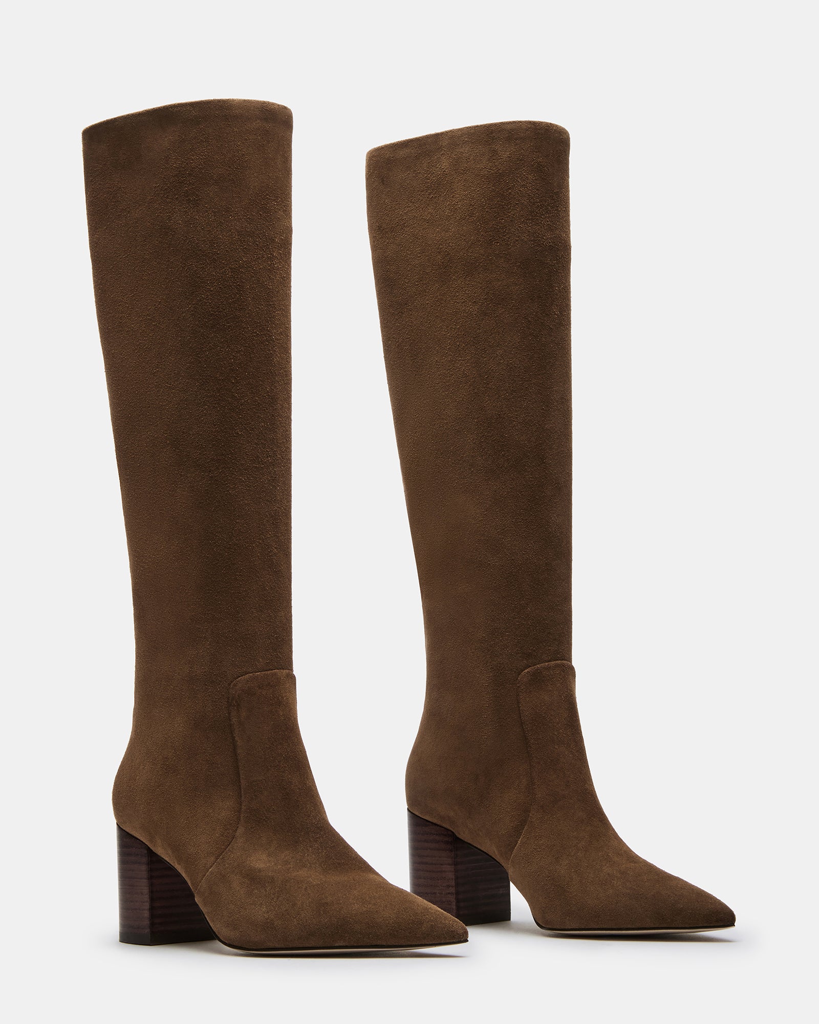 Close-up of pointed toe of brown suede boots with elegant stitching