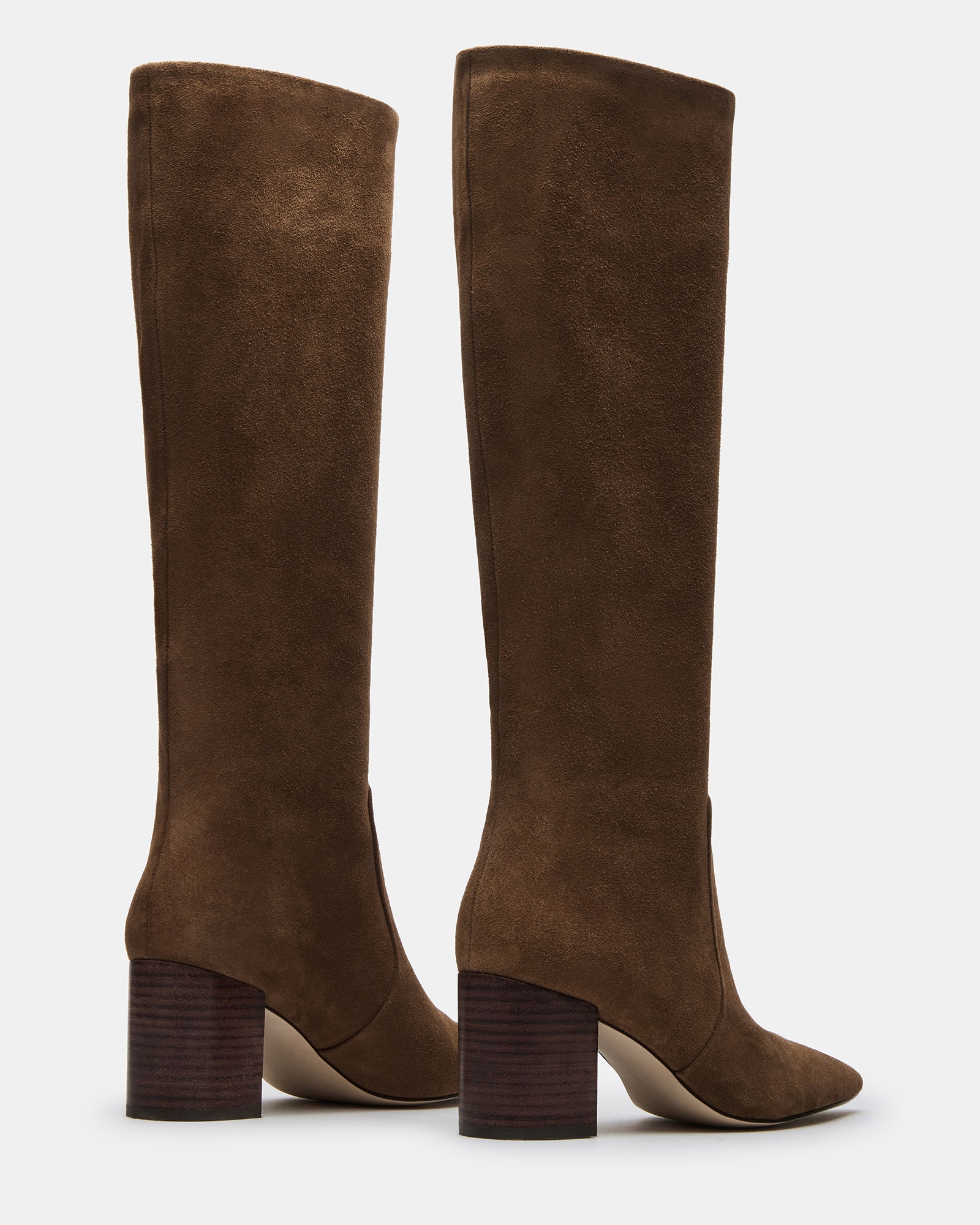 Close-up of pointed toe of brown suede boots with elegant stitching