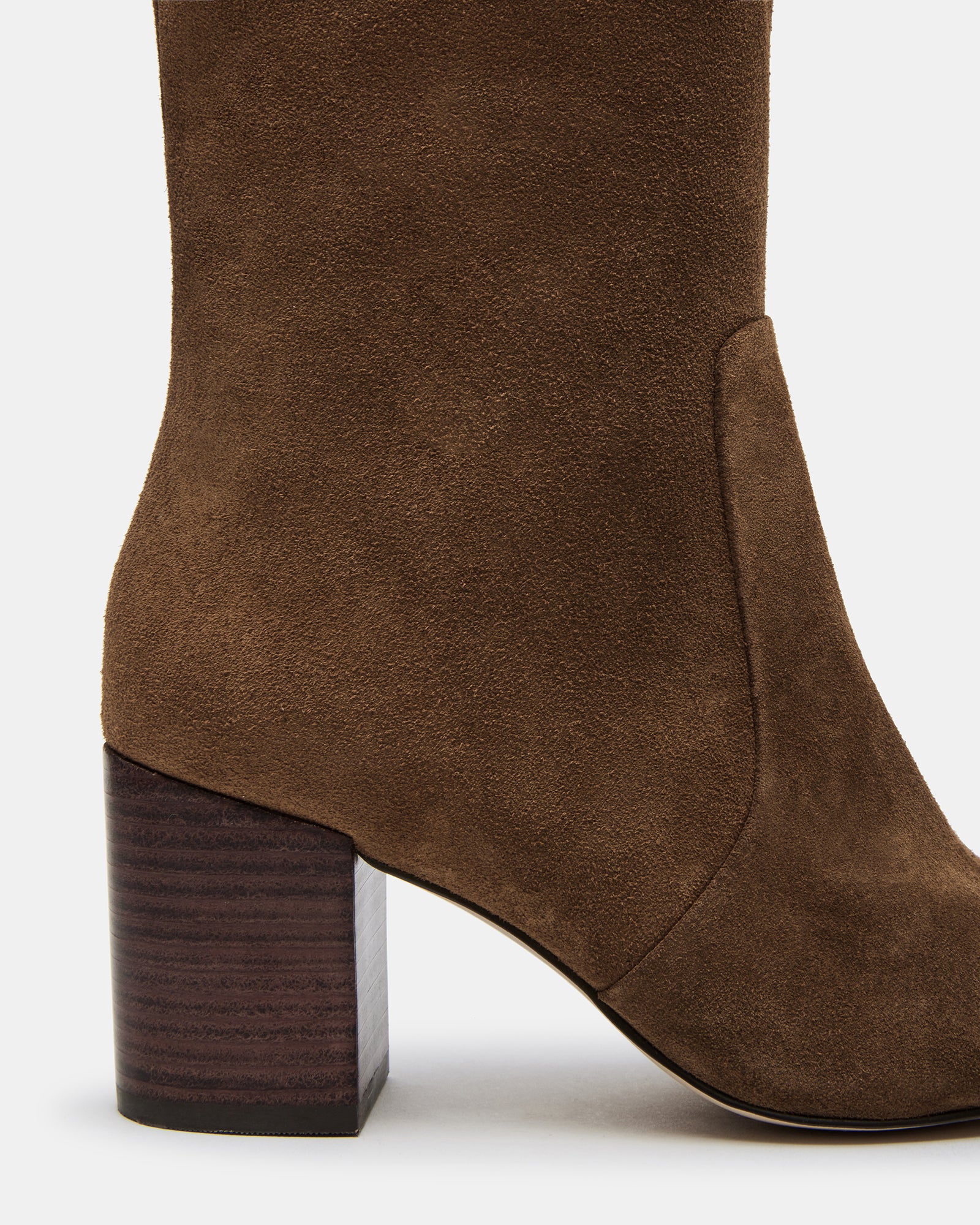 Model wearing brown knee-high boots paired with a chic outfit
