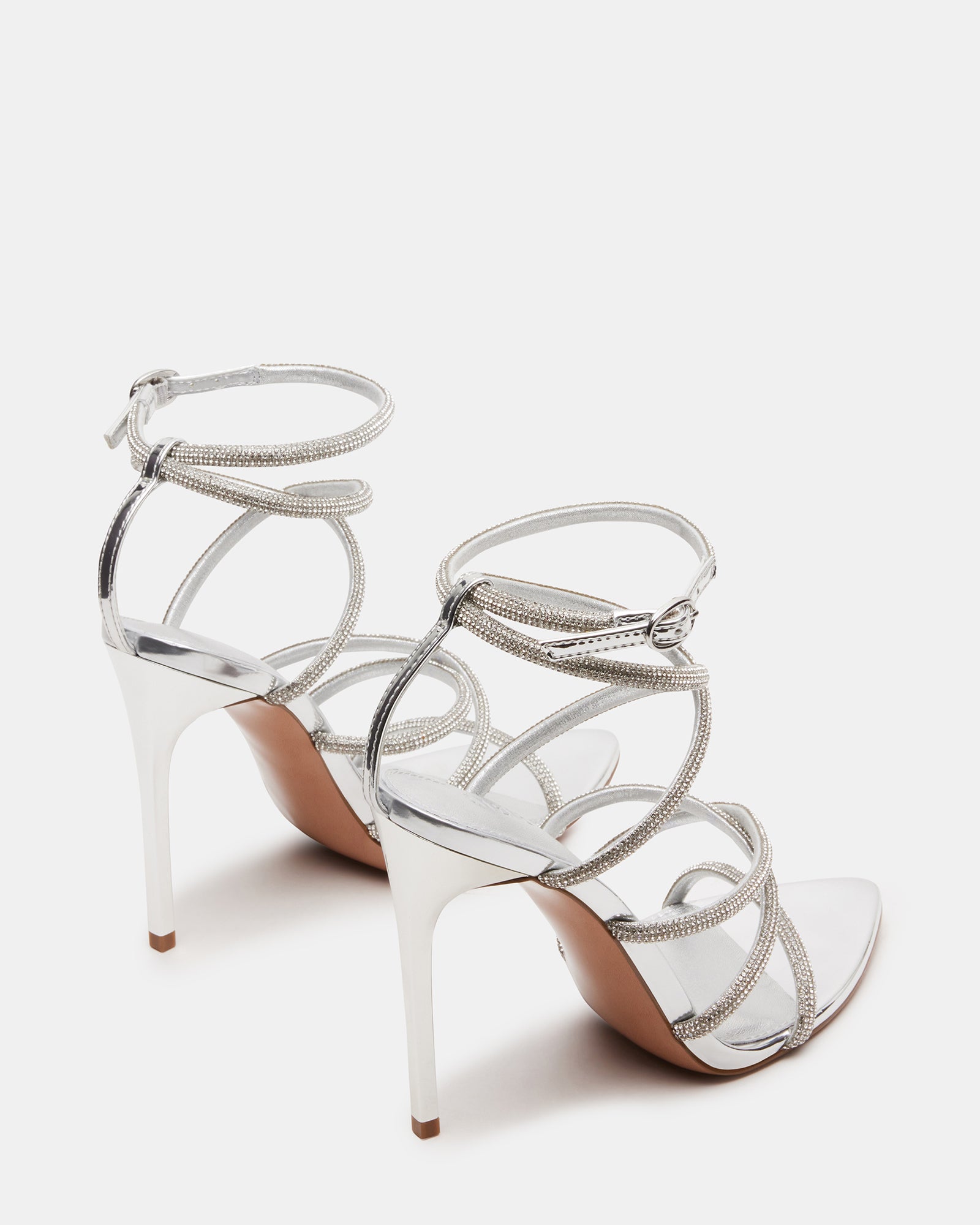 Close-up of pointed toe and rhinestone embellishments on black heels.
