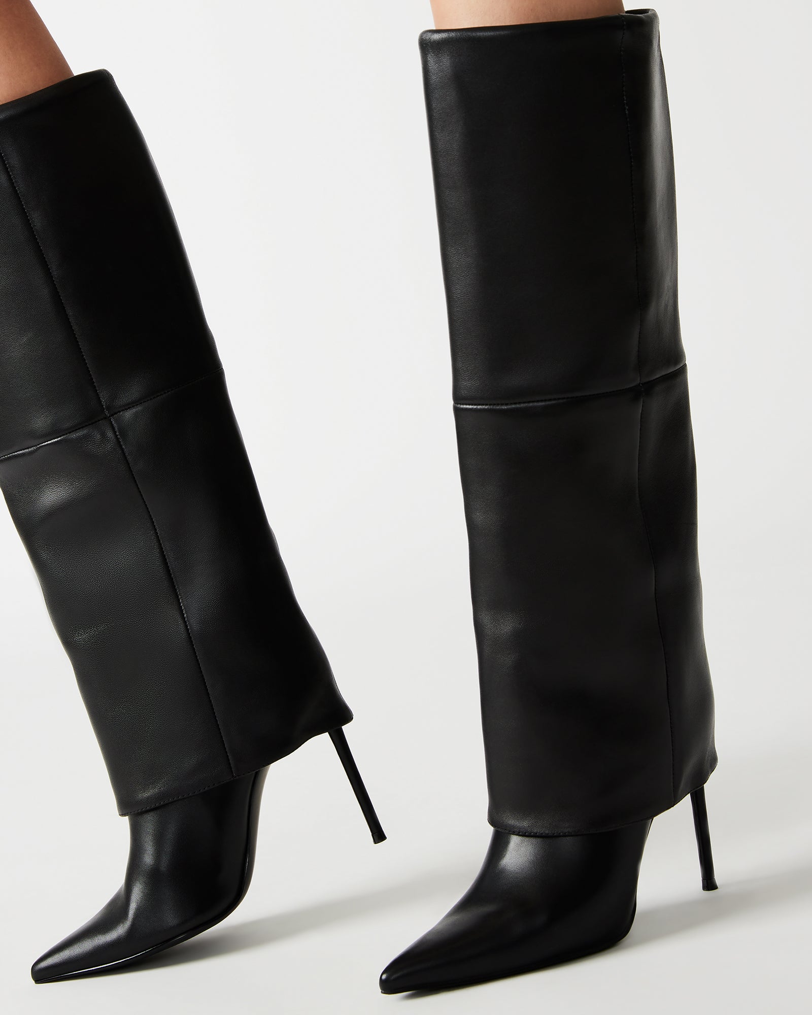 Front view of black stiletto heels styled with denim and oversized coat