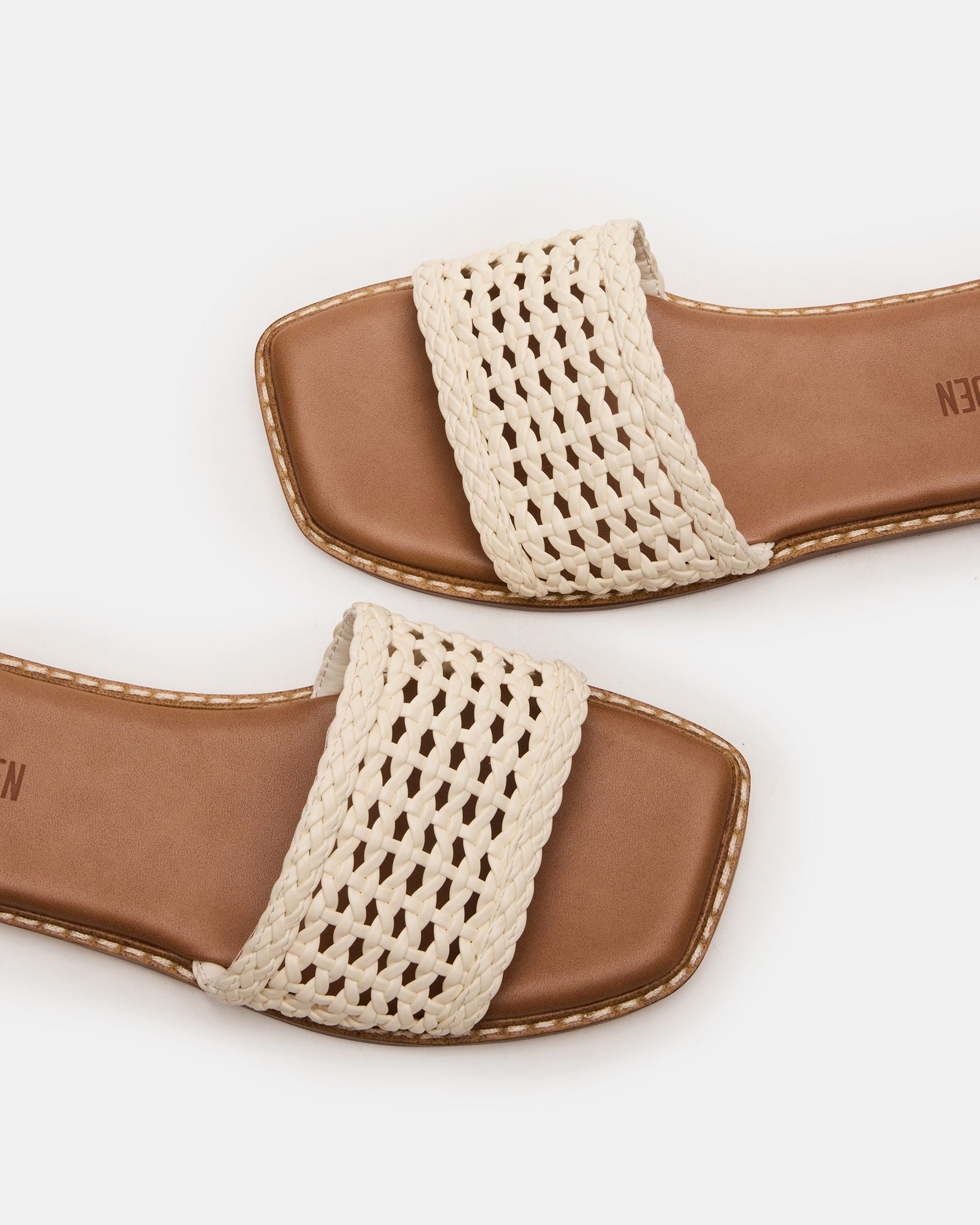 Close-up of square toe sandals resting on patio steps, highlighting the synthetic texture