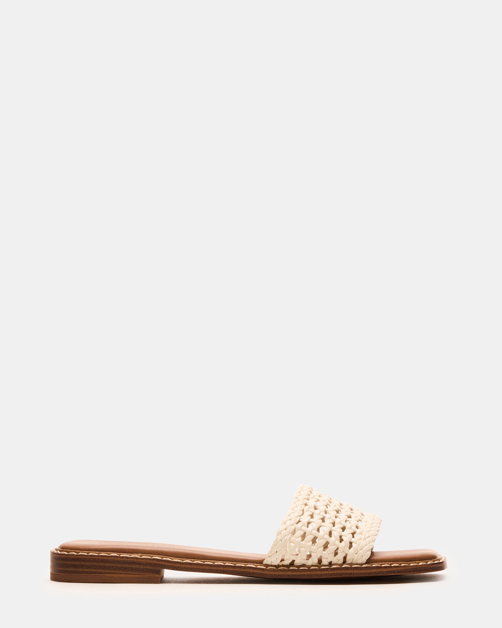 Close-up of square toe sandals resting on patio steps, highlighting the synthetic texture