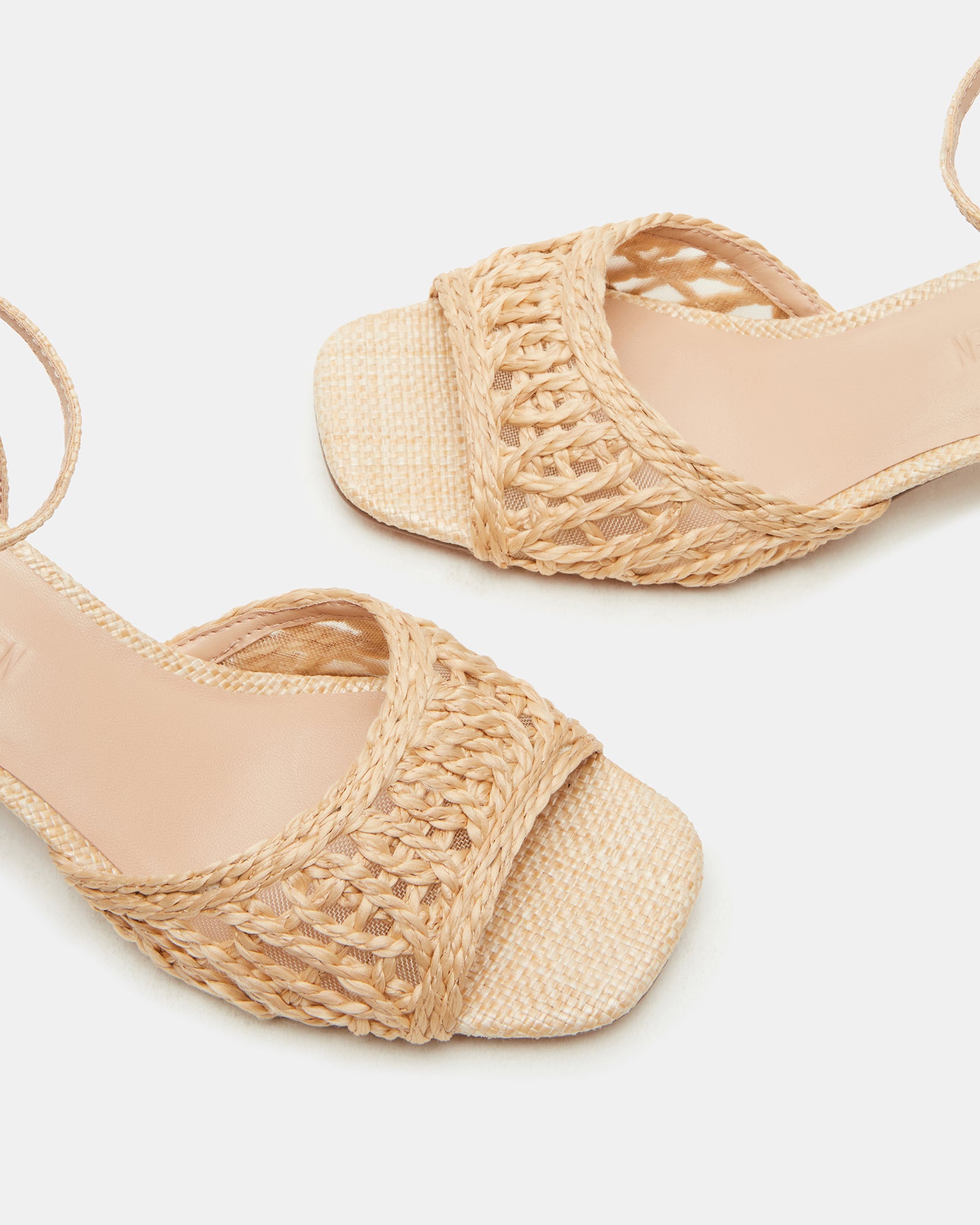 Lifestyle image of black block high heel shoes worn with linen pants at sunset