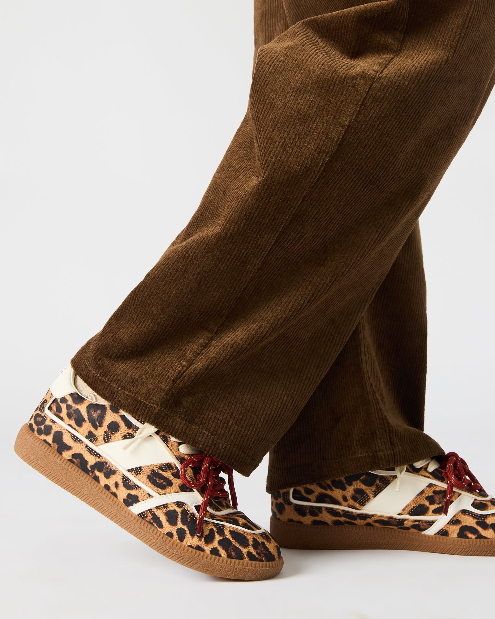 Close-up of lace-up detail and leopard pattern on low-top sneakers