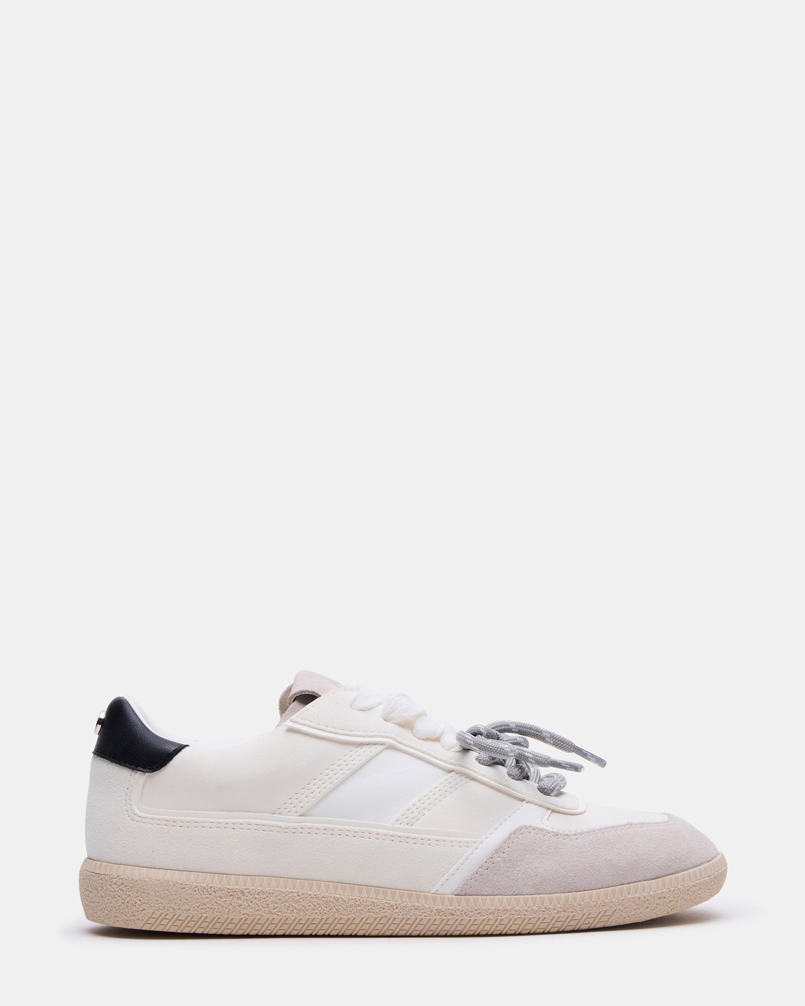 Side view of white men's sneakers with striped laces on concrete