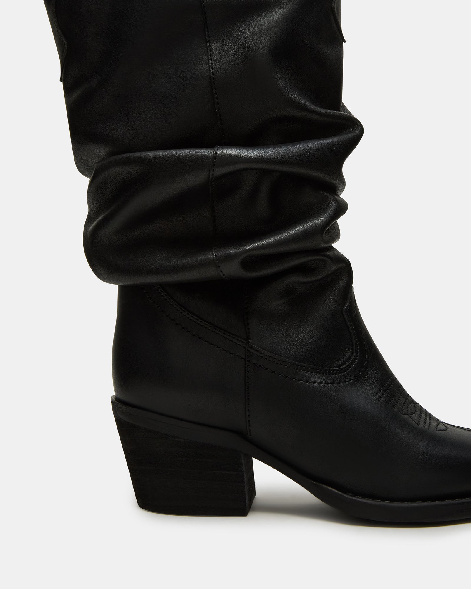 Front view of Stage black leather cowboy boots on wooden floor