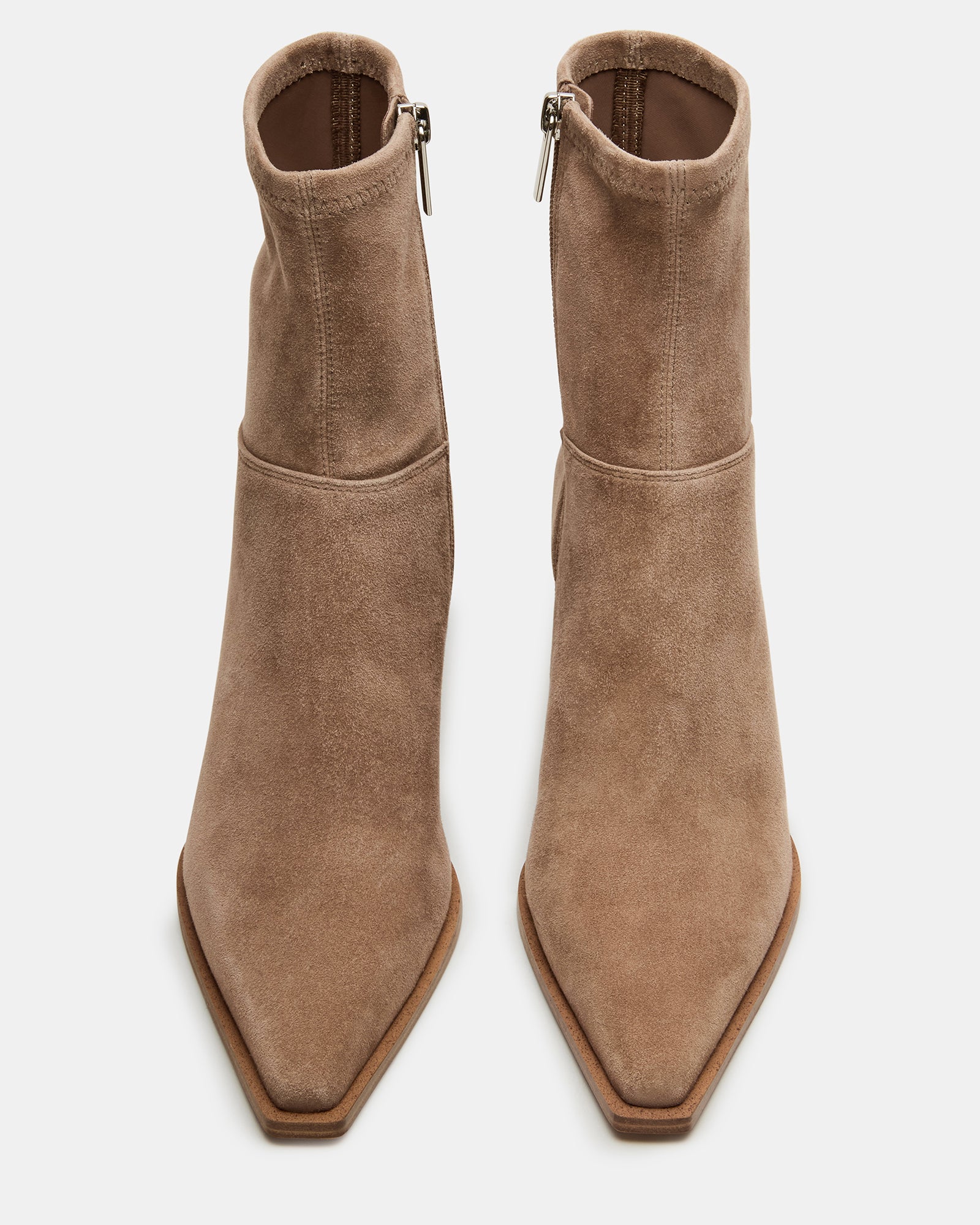Rear angle of suede brown booties styled with cropped jeans on a sidewalk.