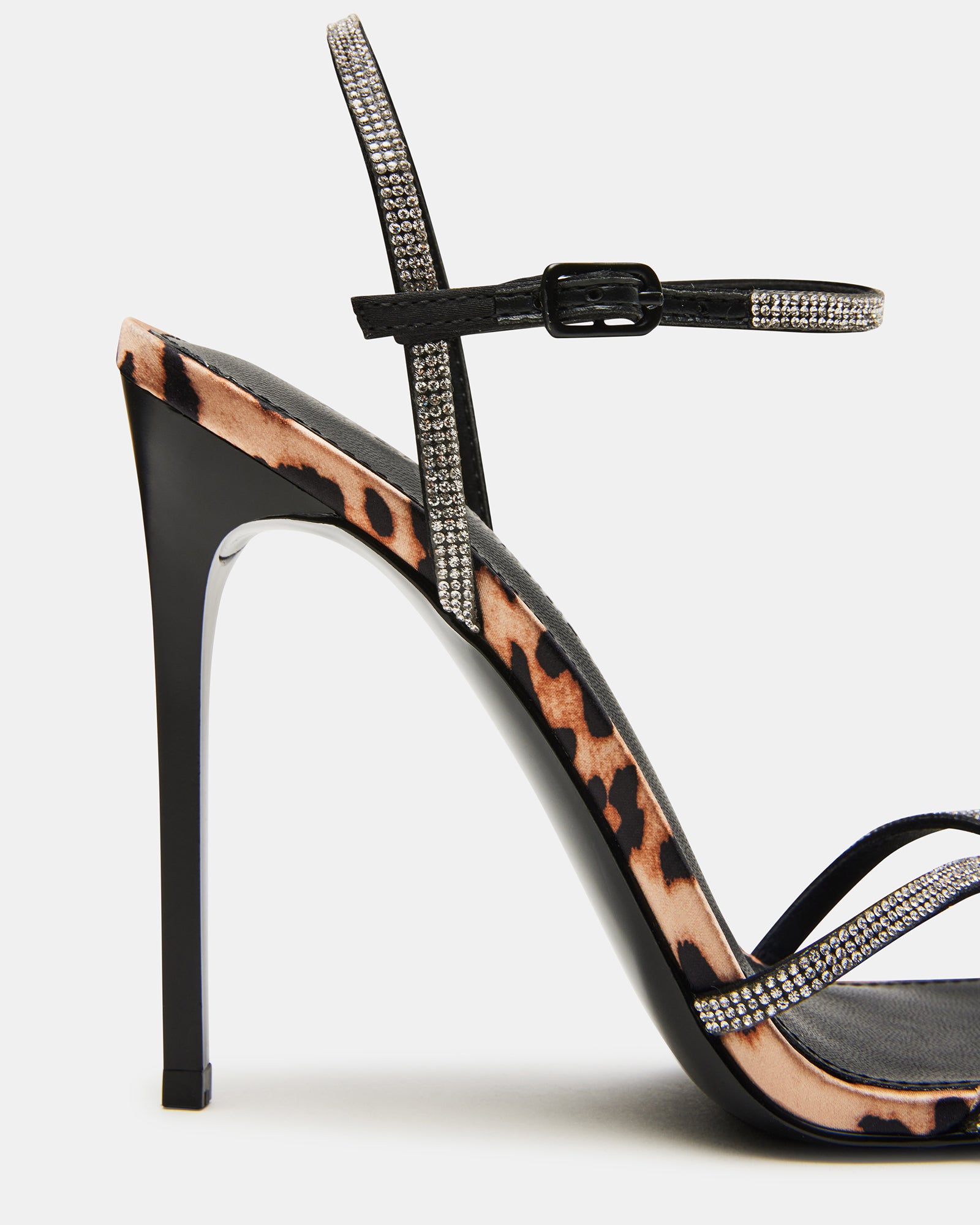 Close-up of the detailed textile upper with stones on the nude strappy sandals.
