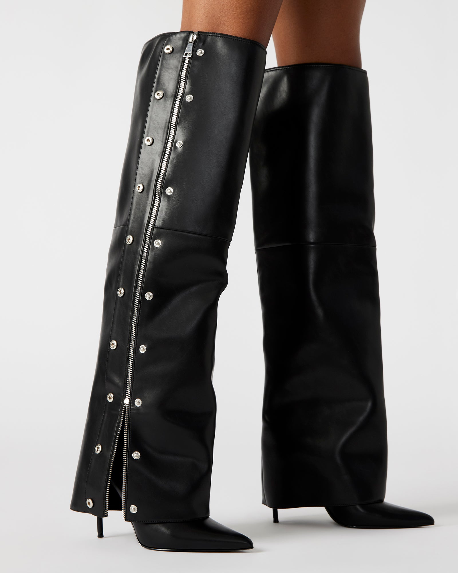 Close-up of studded toe detailing on brown knee high boots with pointed silhouette