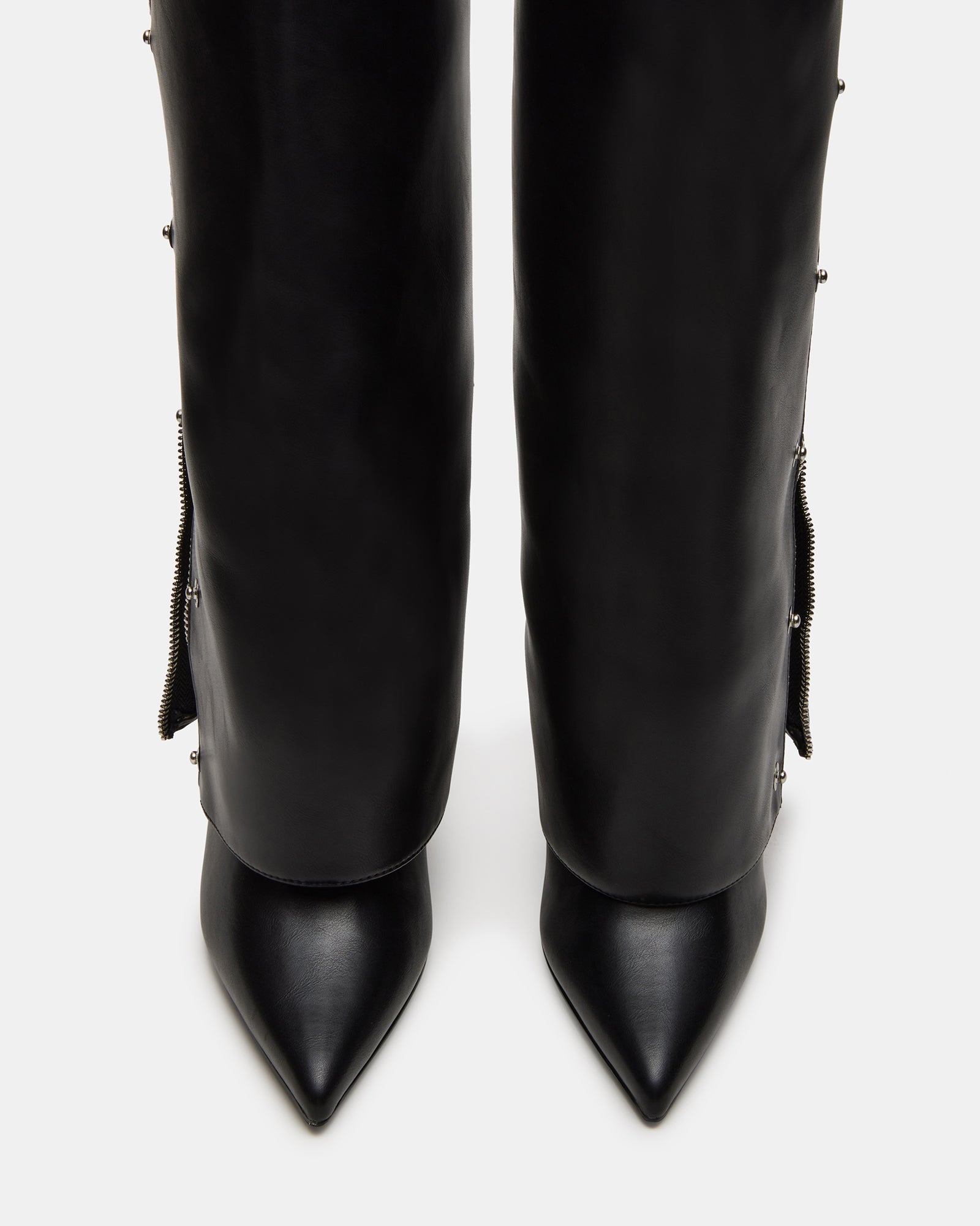 Close-up of studded toe detailing on brown knee high boots with pointed silhouette