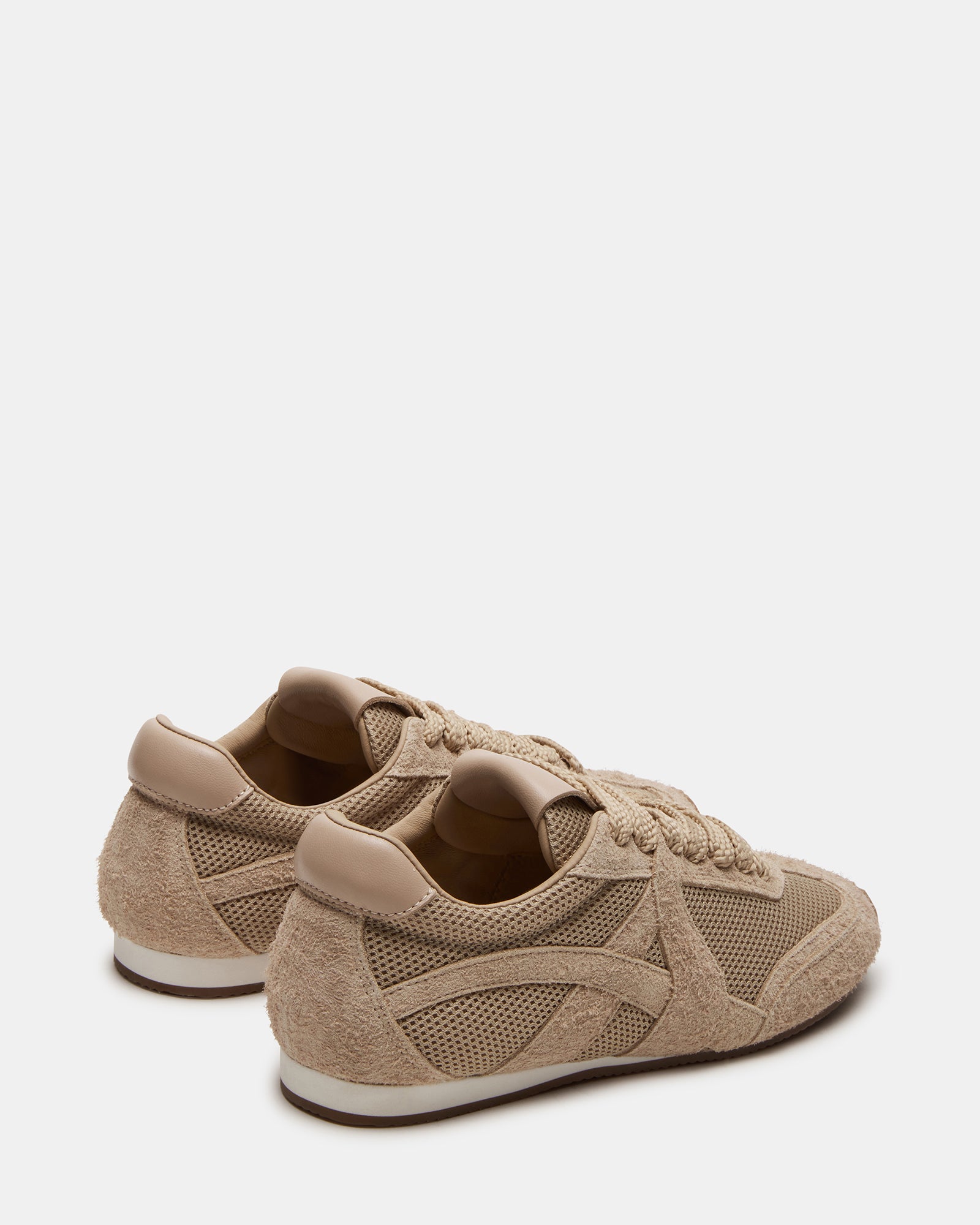Close-up of Stride Blush sneakers highlighting the textured suede and lace-up detail.