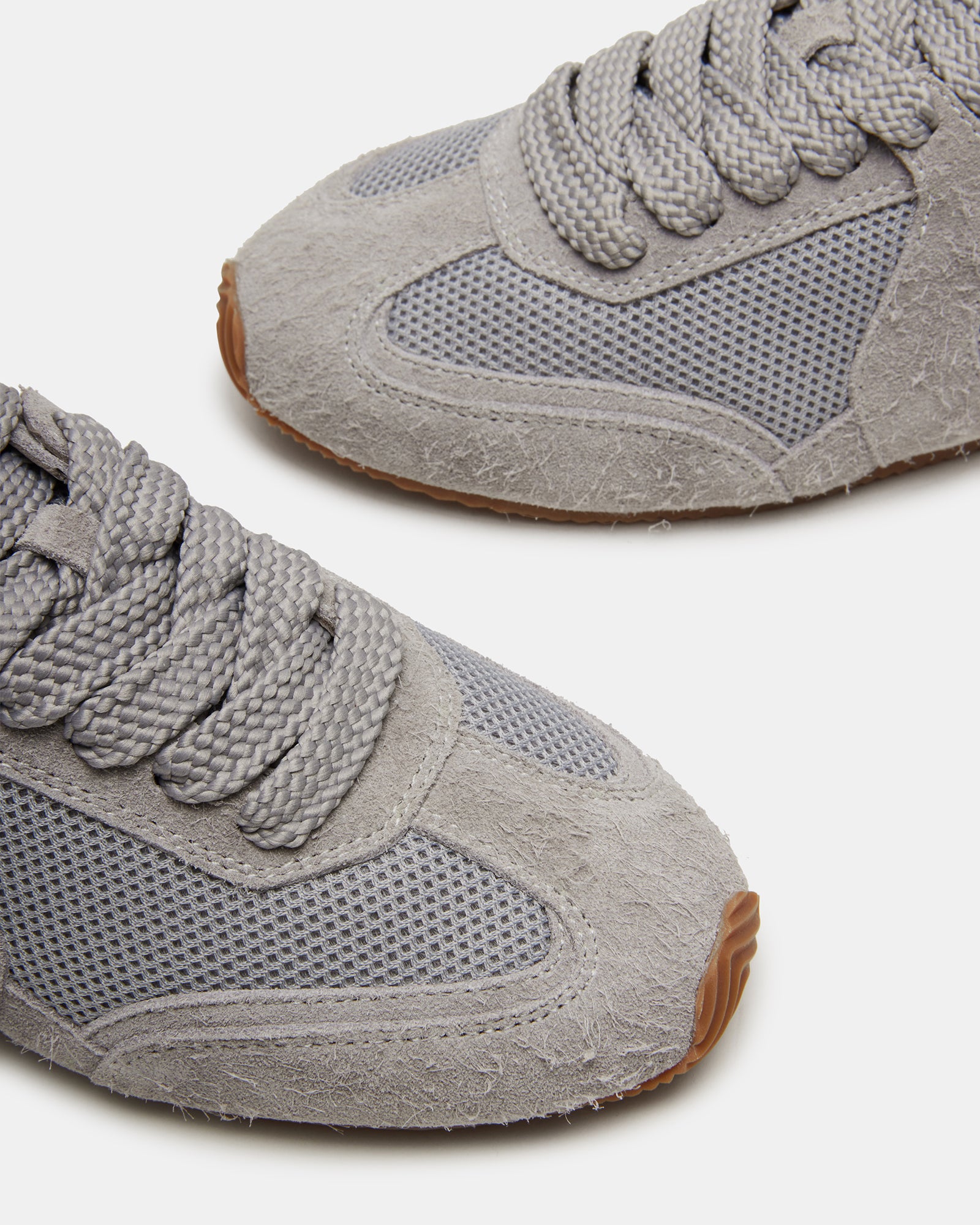 Side view of Stride Grey Suede sneakers highlighting flat sole