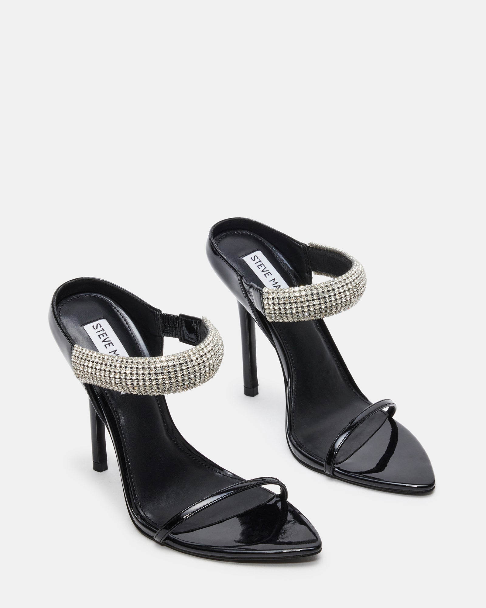 Model wearing black heels with rhinestones at a party.