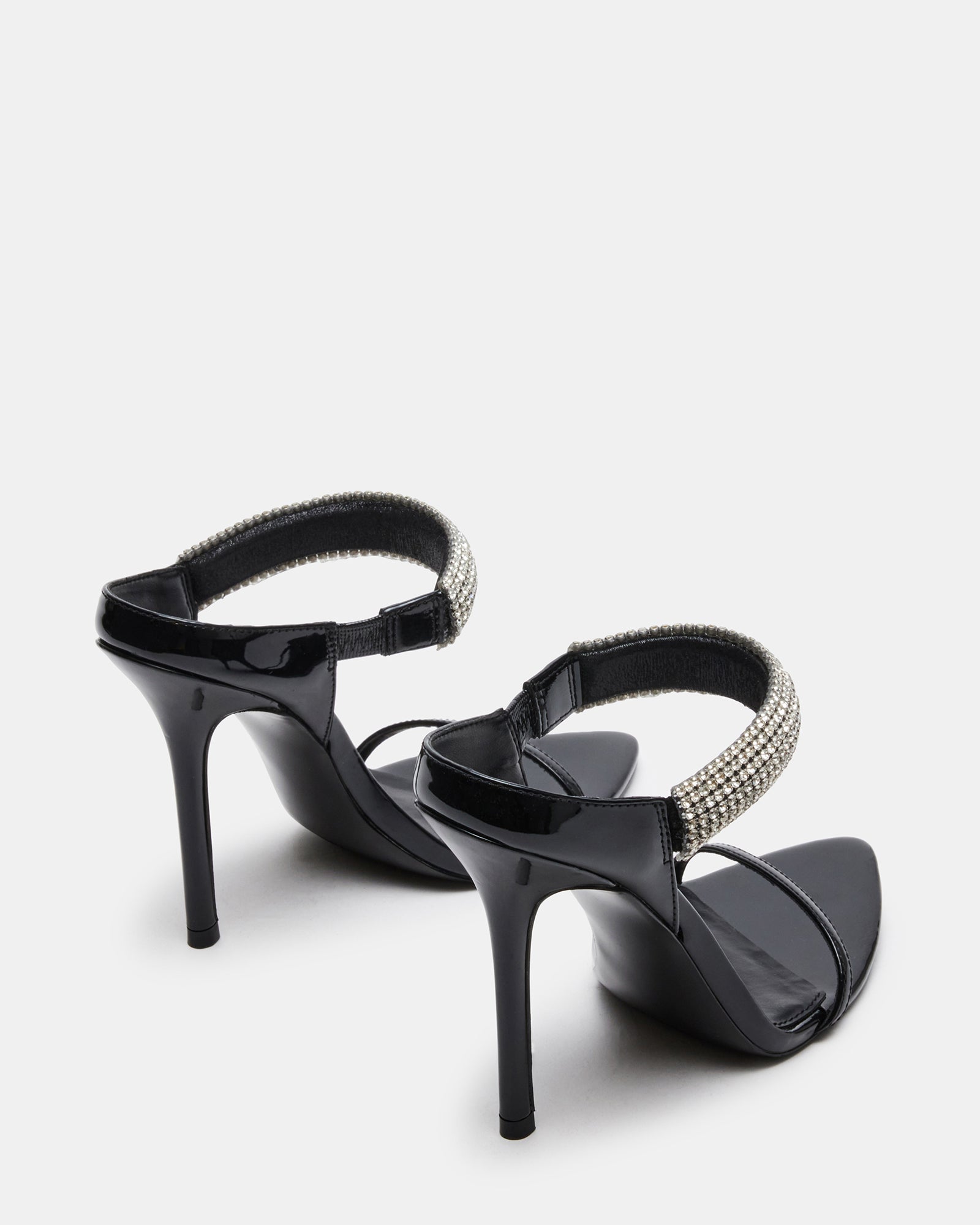 Model wearing black heels with rhinestones at a party.