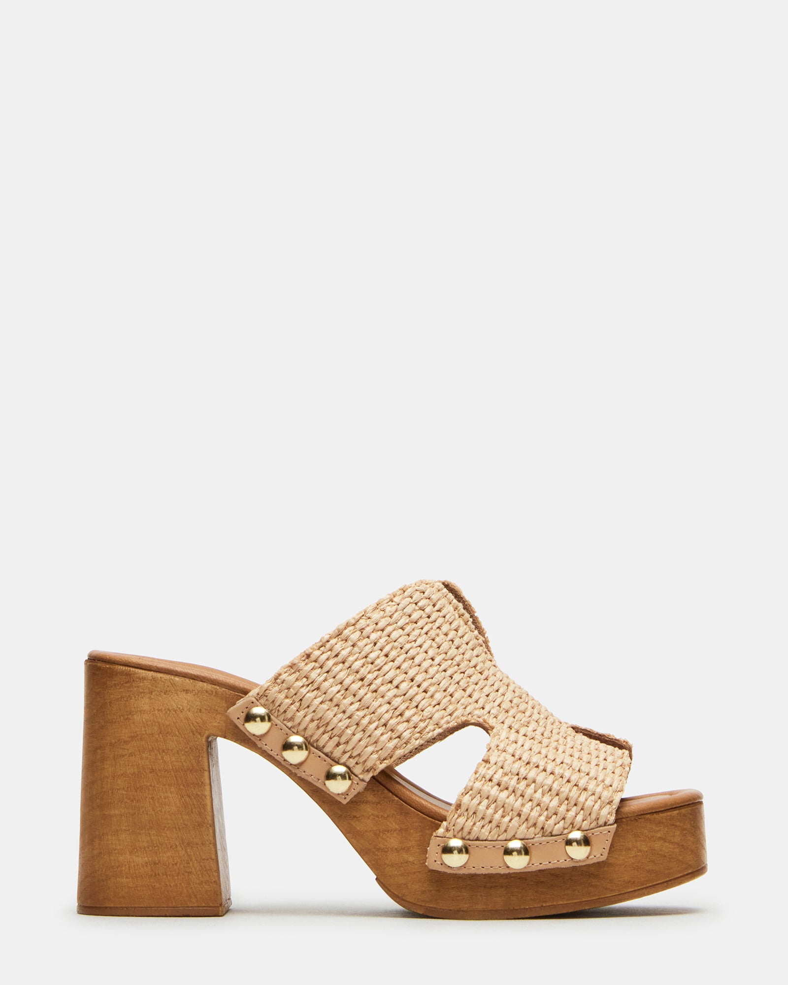 Close-up of raffia platform sandals with stud details on a sunny patio