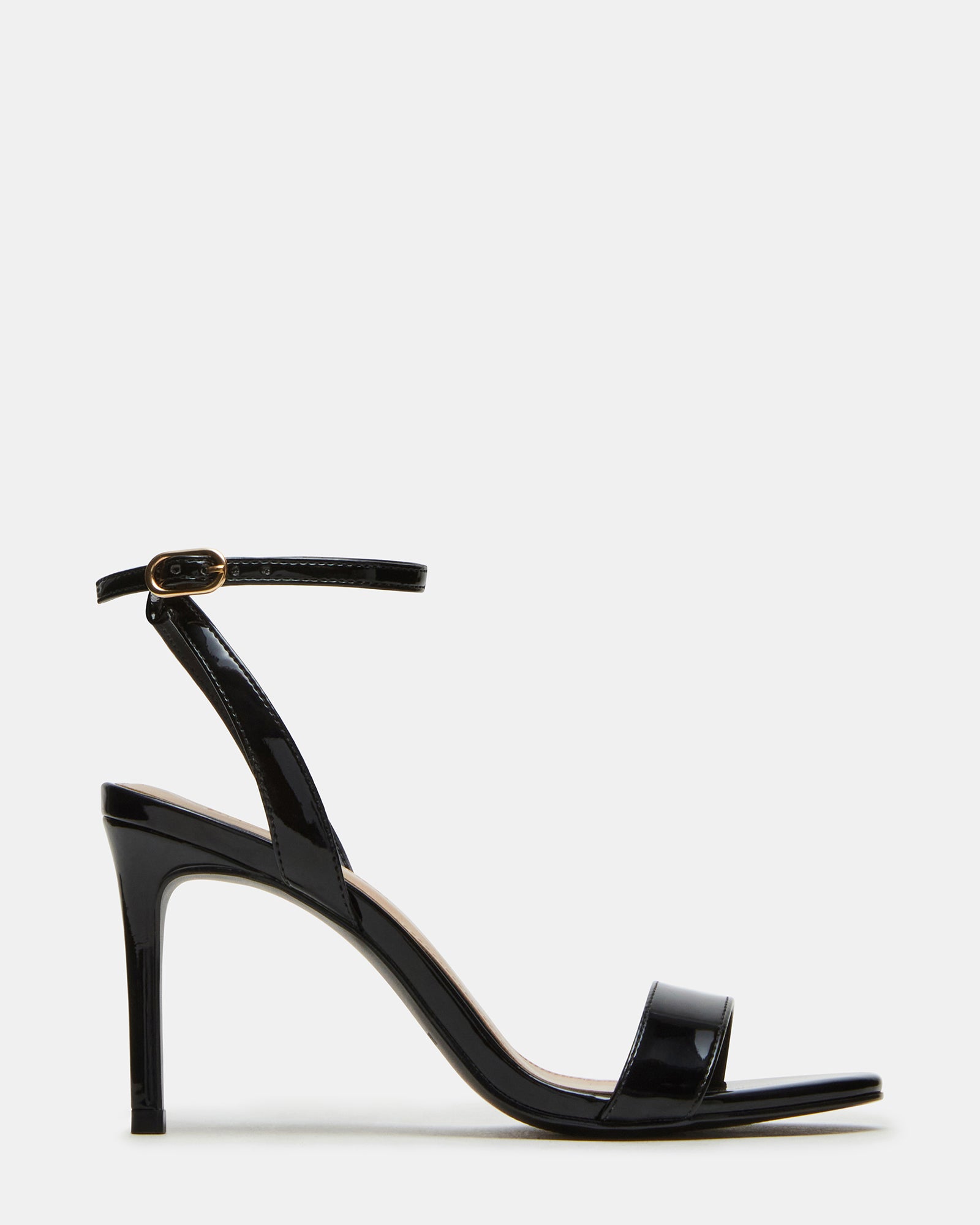 Black patent leather ankle strap heels worn with evening dress, front angle