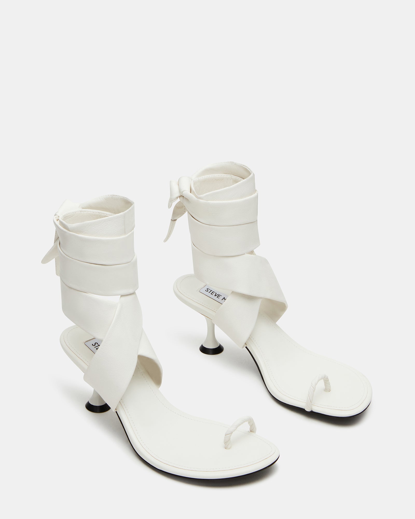 Chic white leather heels showcasing a strappy design, perfect for brunch.