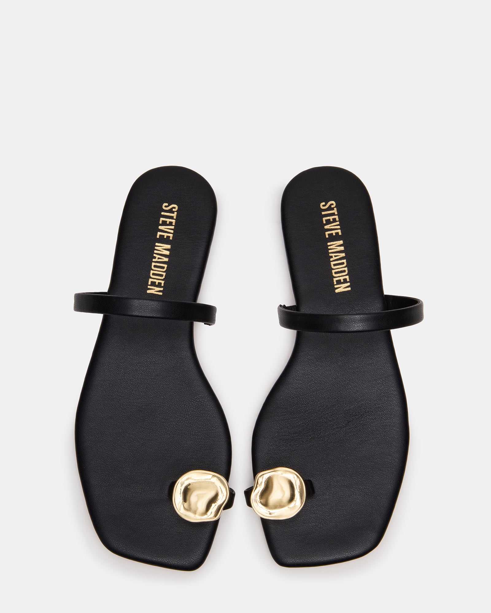 Side view of black flat sandals showcasing their sleek design.