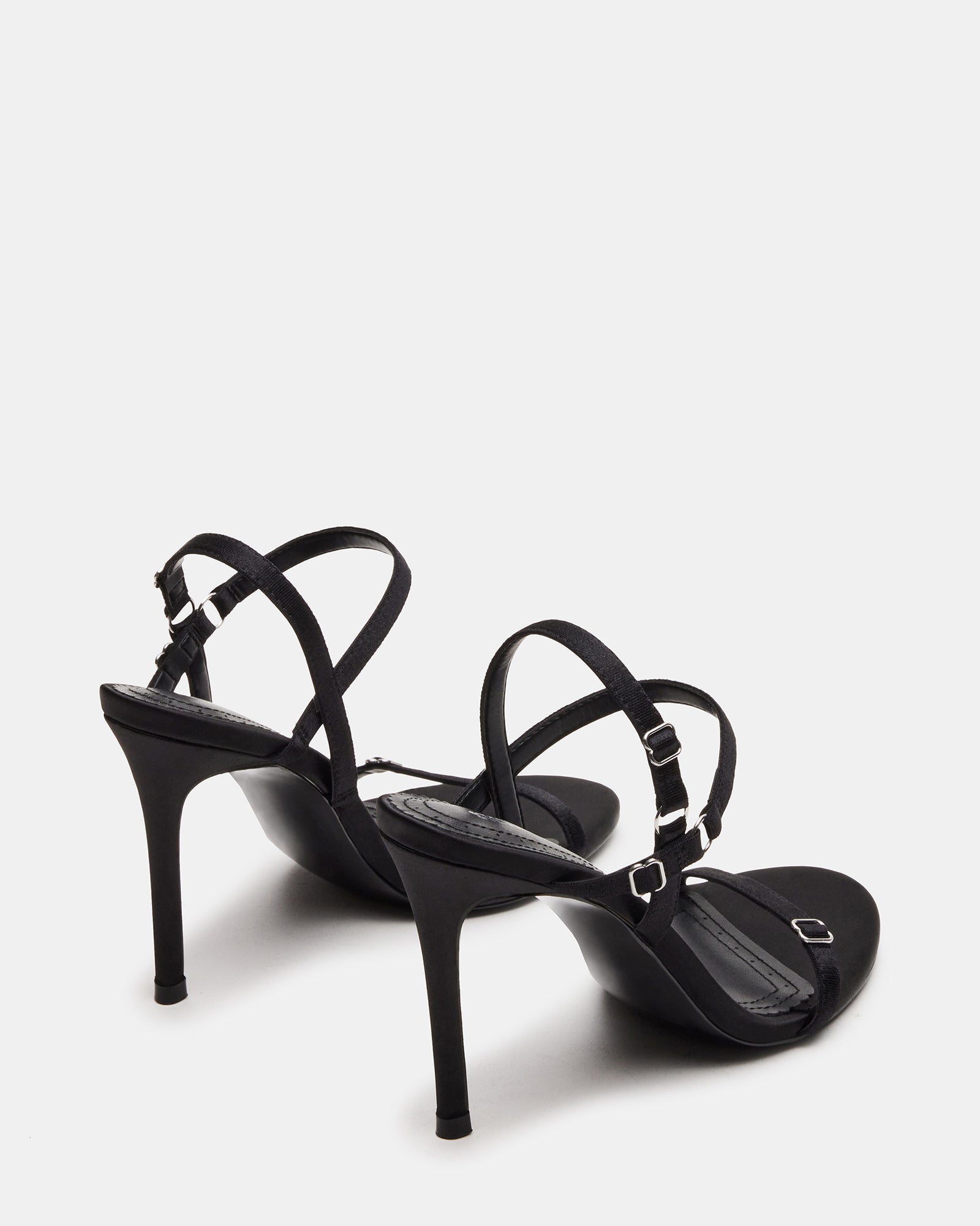 Close-up of satin straps and heel silhouette on black platform heels