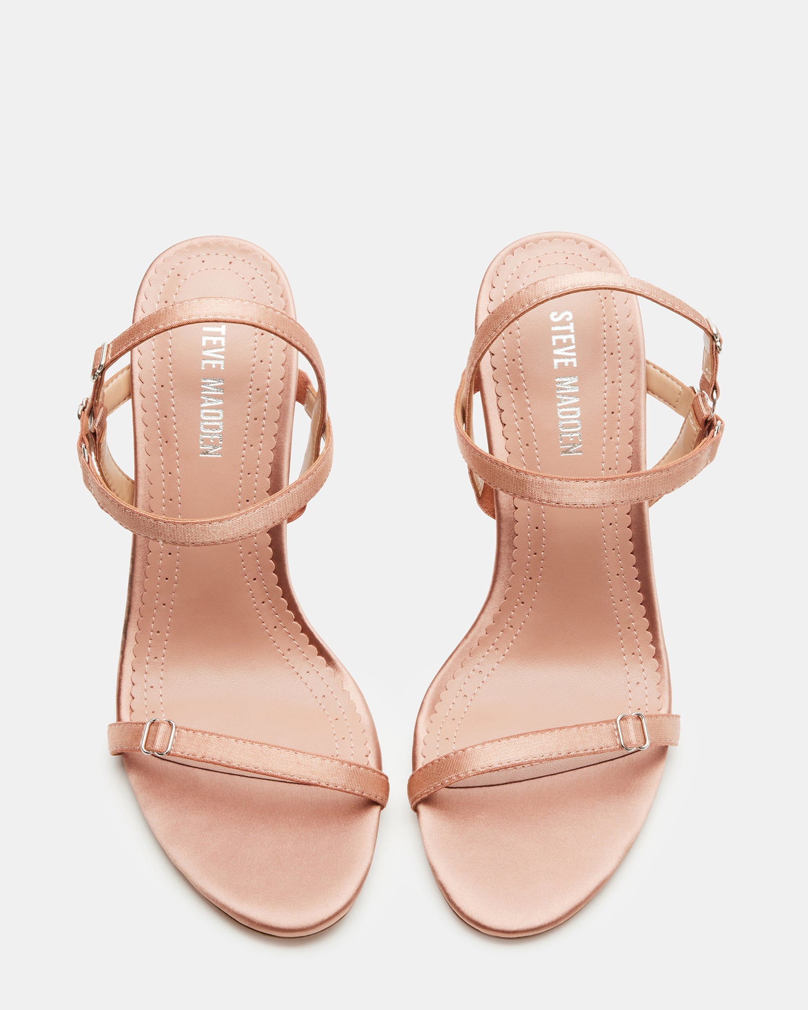 Side view of TANA blush satin open toe heels with straps on a model