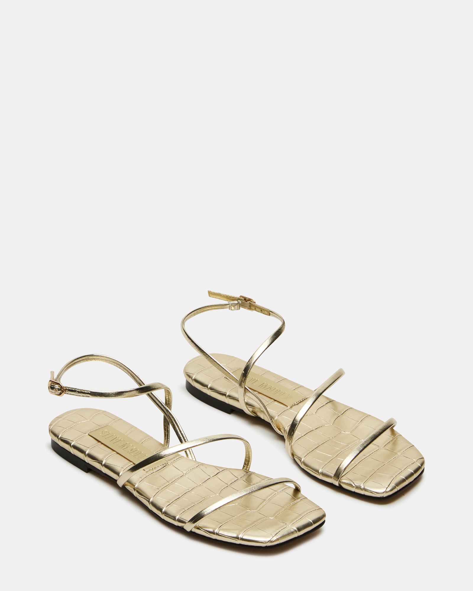 Model wearing TANGO Gold vegan leather sandals paired with a summer dress