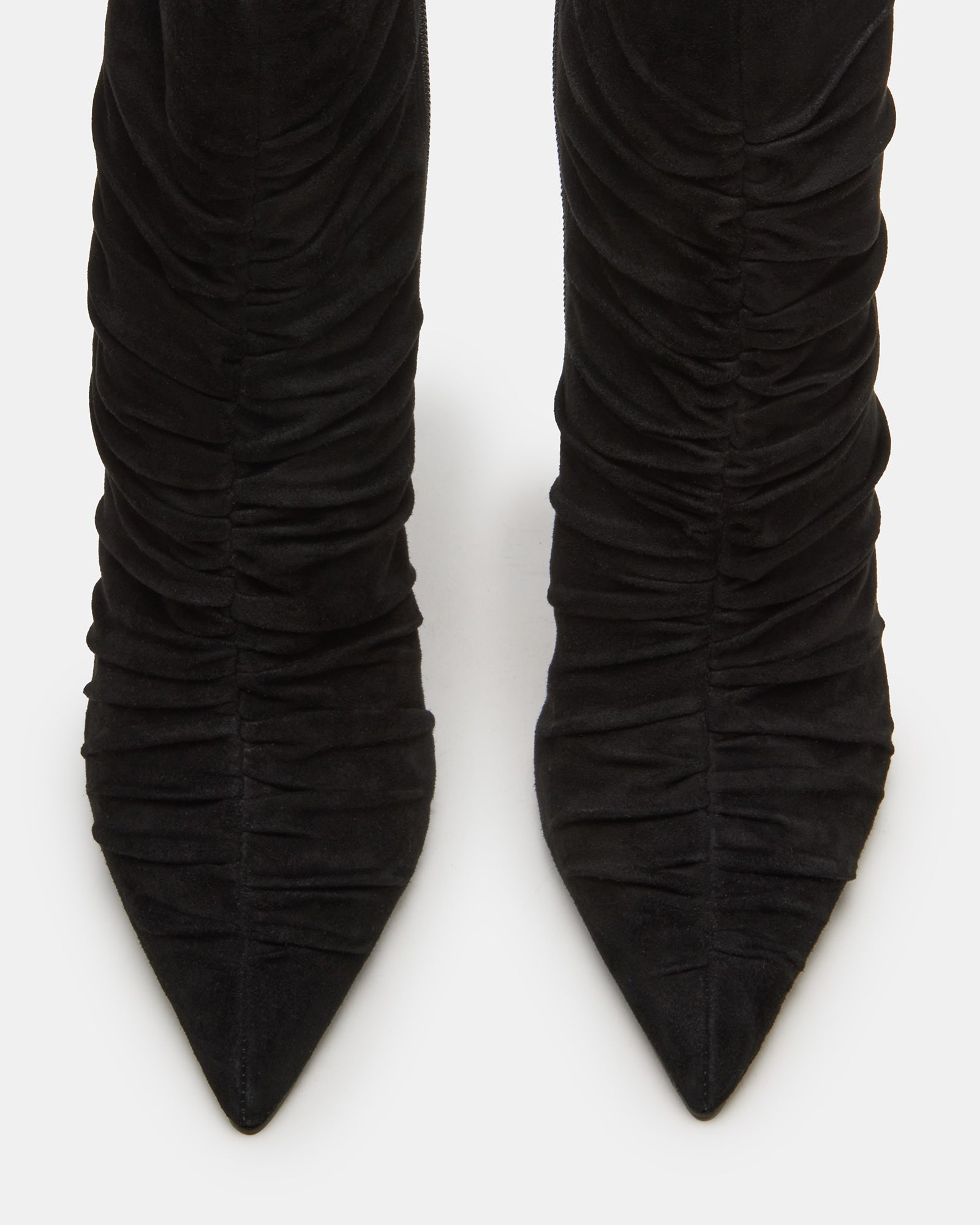 Black suede pointed toe ankle booties with stiletto heel on a stylish model