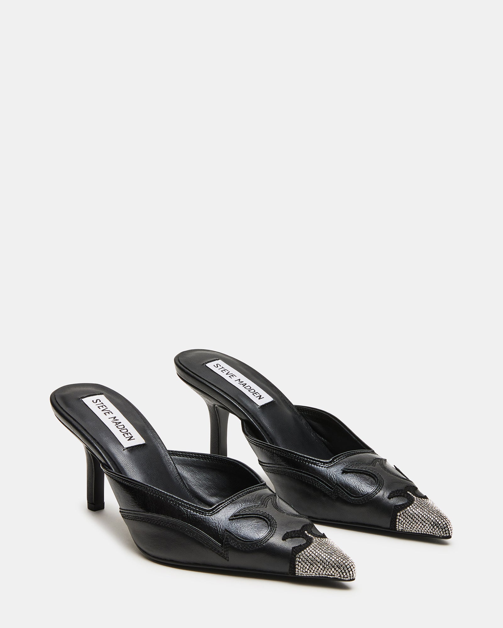 Close-up of the pointed toe of black mule shoes with rhinestone detailing.