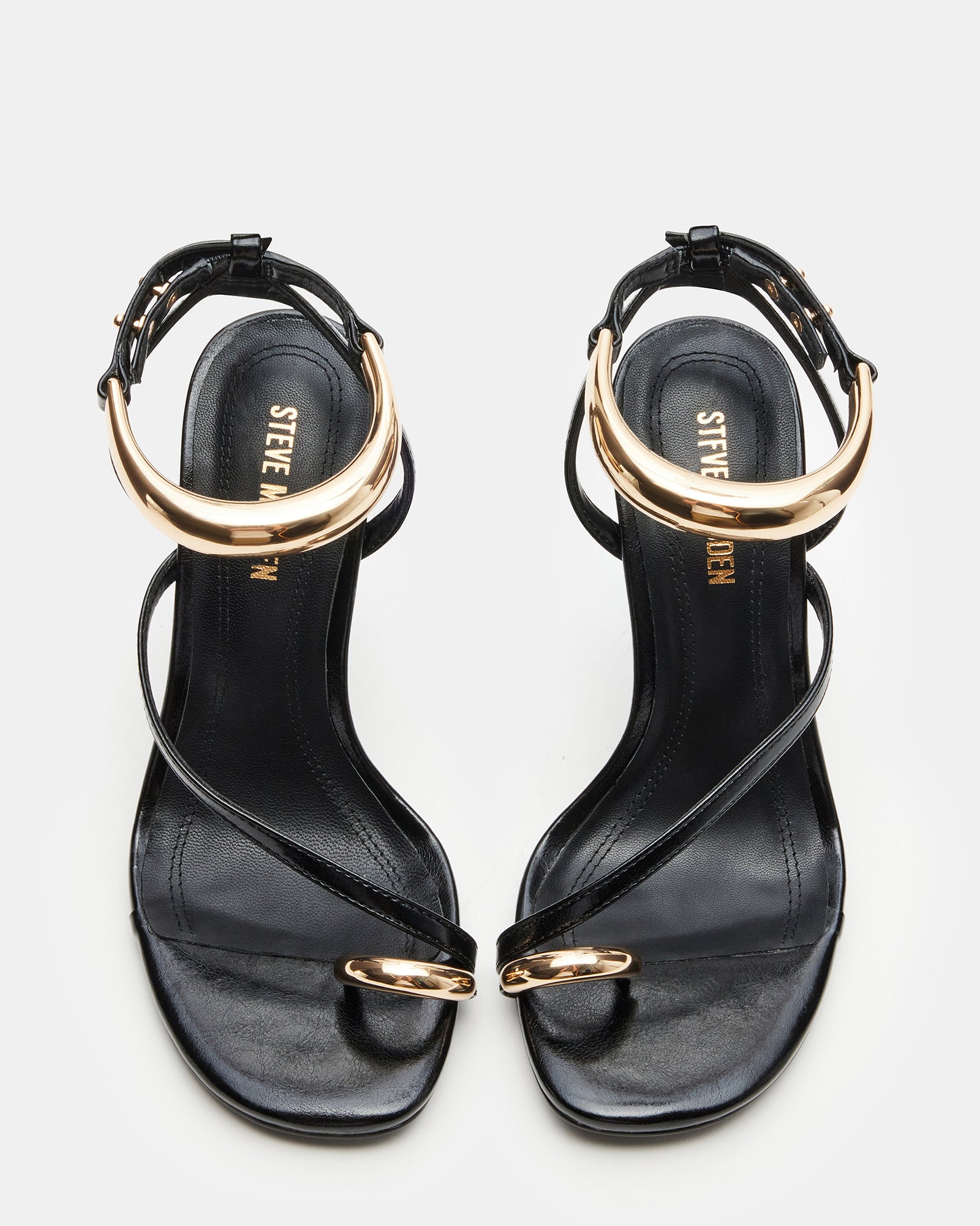 Strappy black stiletto heels with platform sole on a models foot