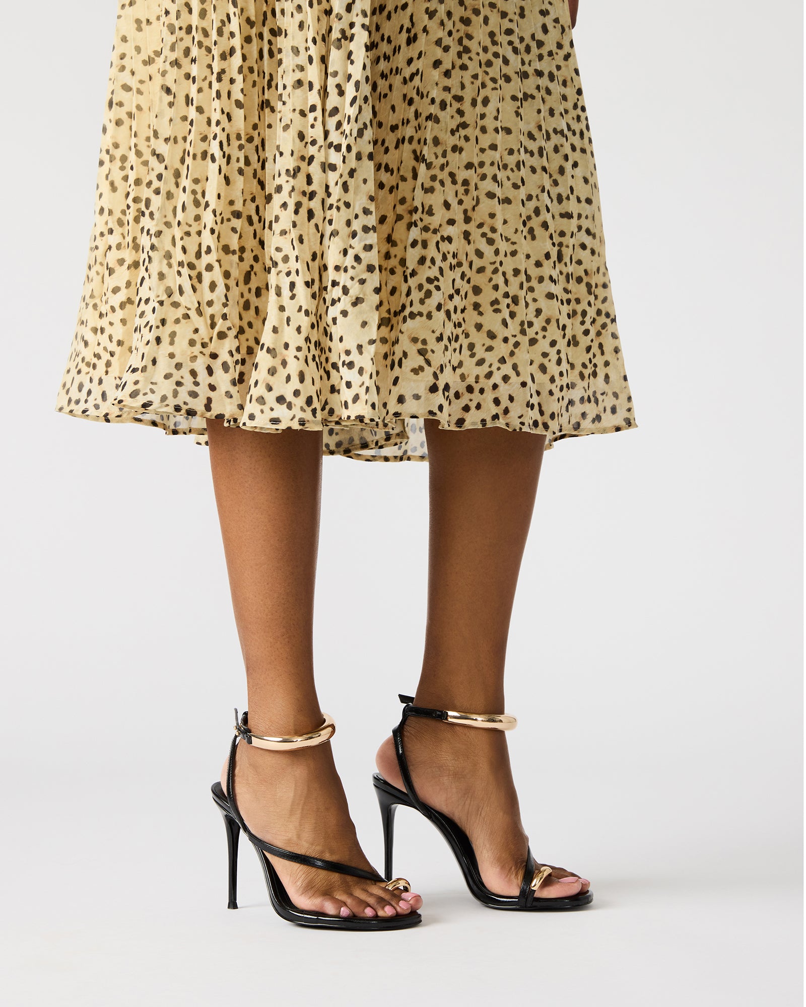Strappy black stiletto heels with platform sole on a models foot