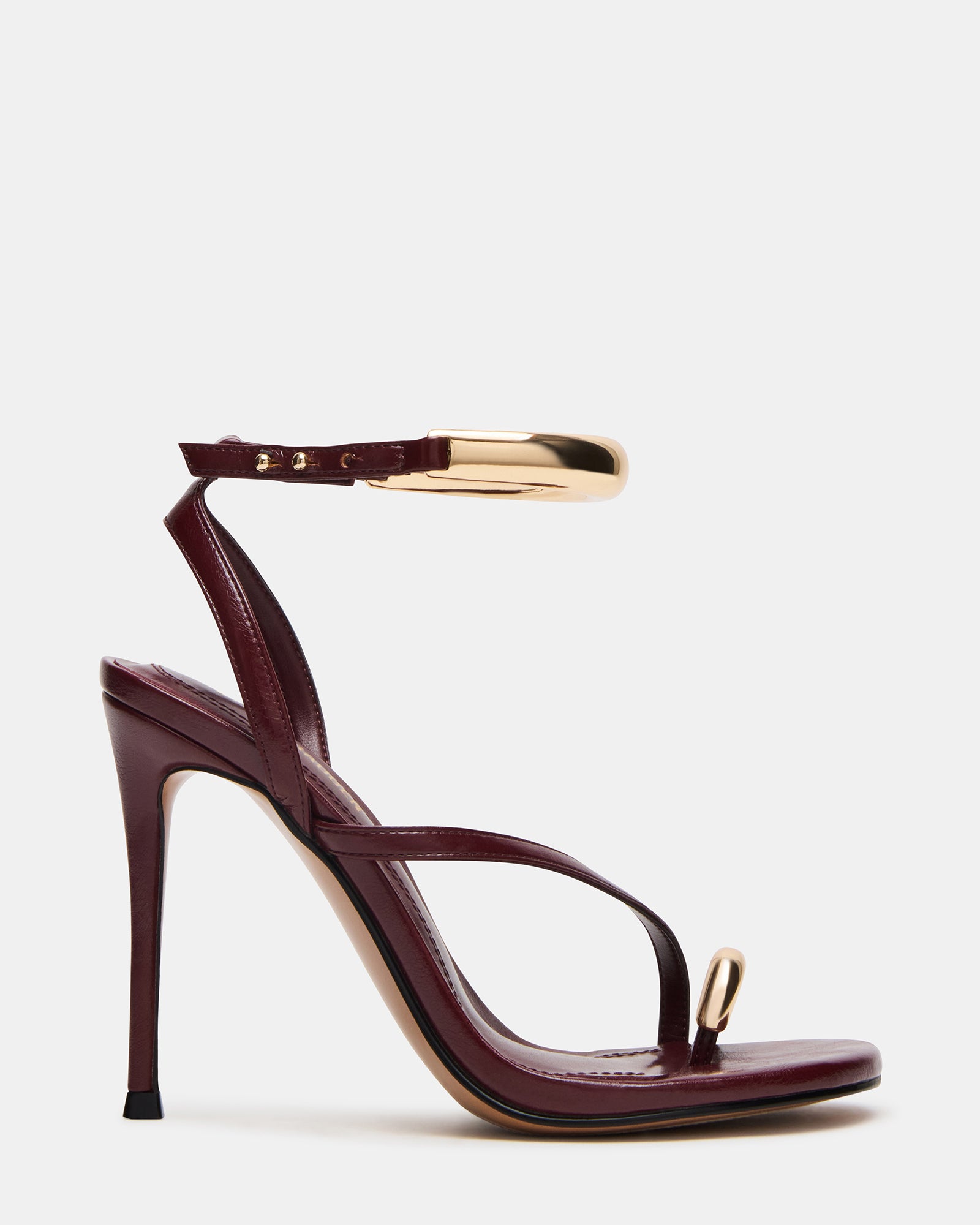 Gold strappy stiletto heels on a marble background