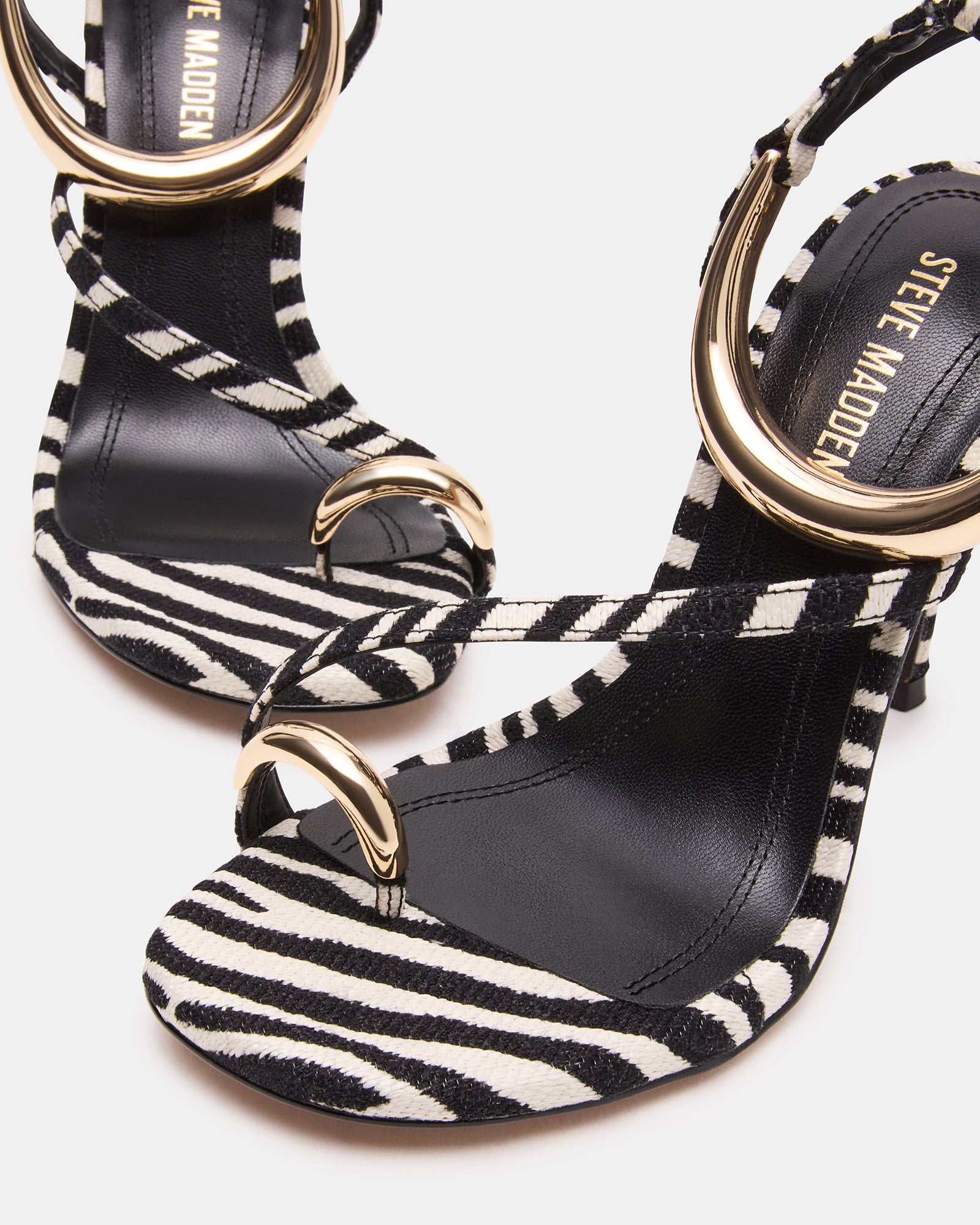 Side view of elegant gold strappy heels, showcasing the stiletto design.