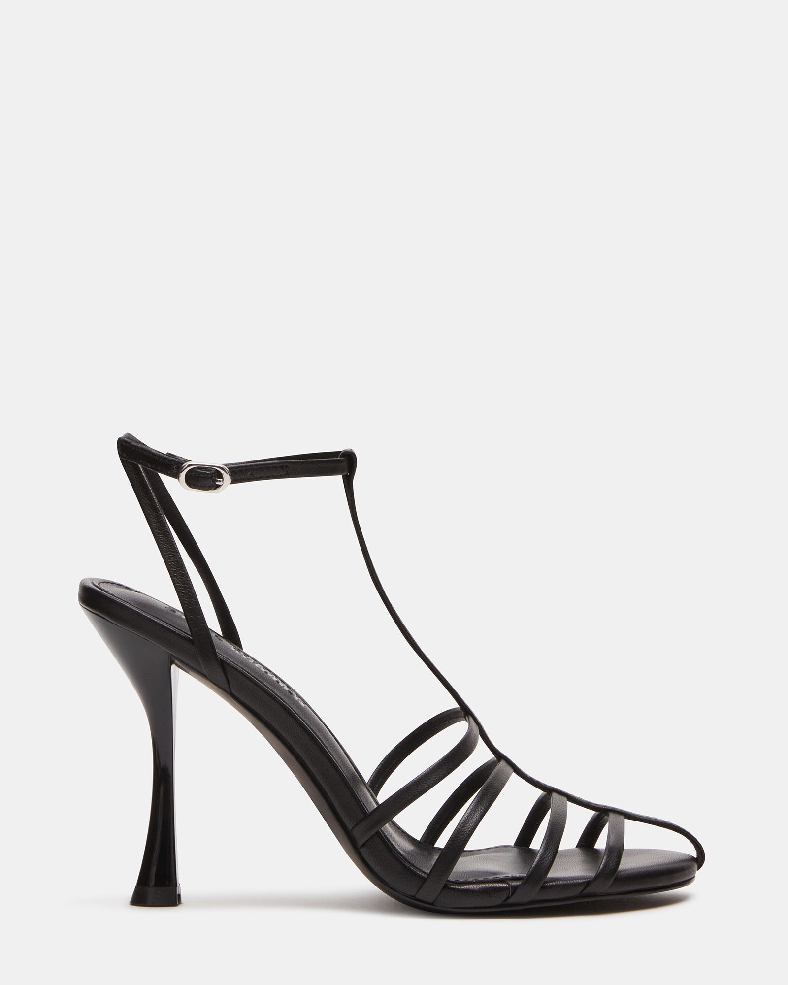 Close-up of black high heels with t-strap and ankle closure on hardwood floor