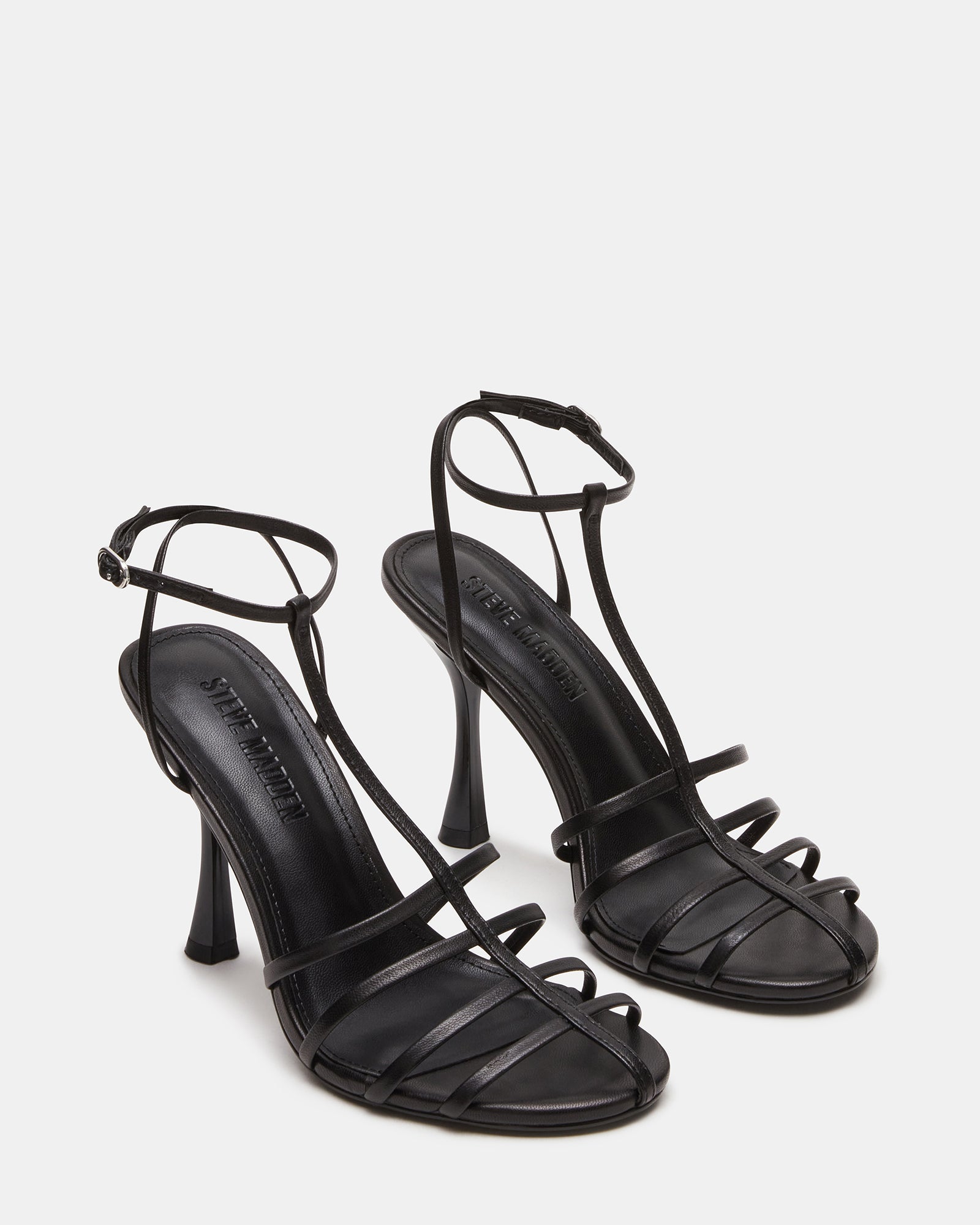 Overhead shot of womens shoes with rounded toe and buckle strap, resting on a marble surface