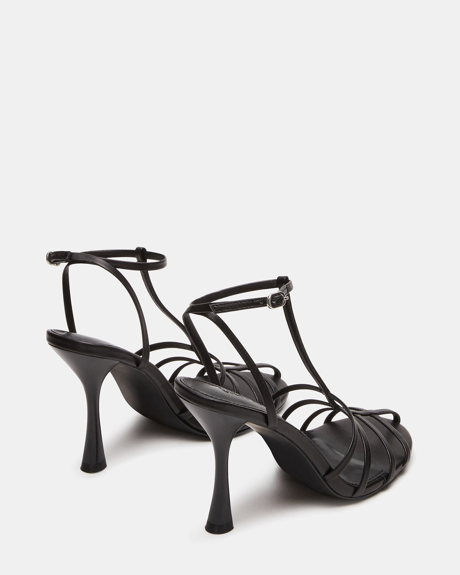 Overhead shot of womens shoes with rounded toe and buckle strap, resting on a marble surface