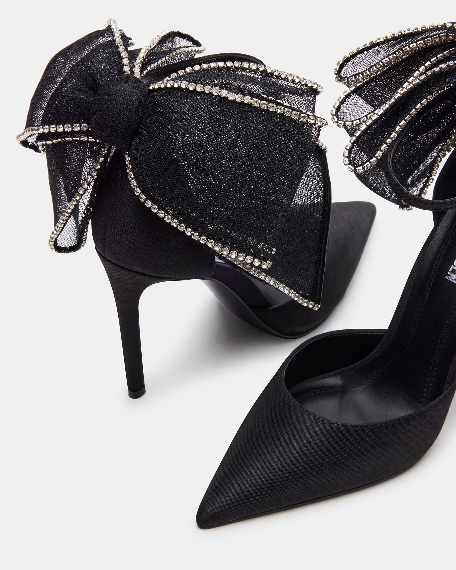 Timeless black satin high heels on a wooden floor
