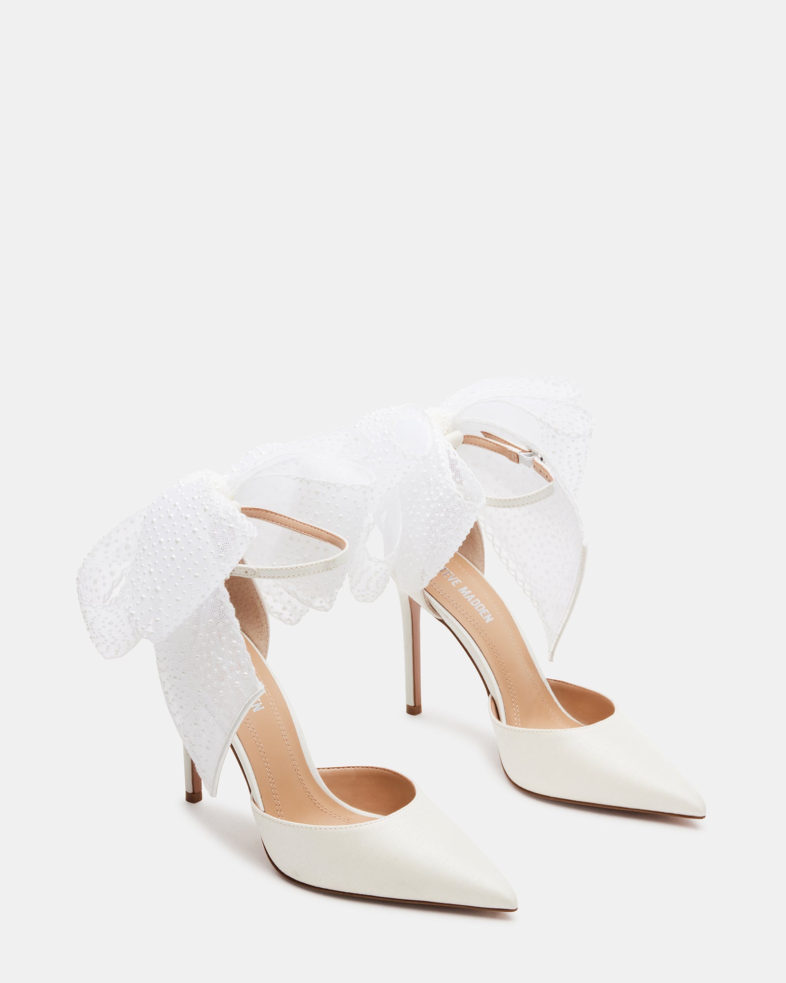 Close-up of the pearl embellishments on the satin bridal shoes.