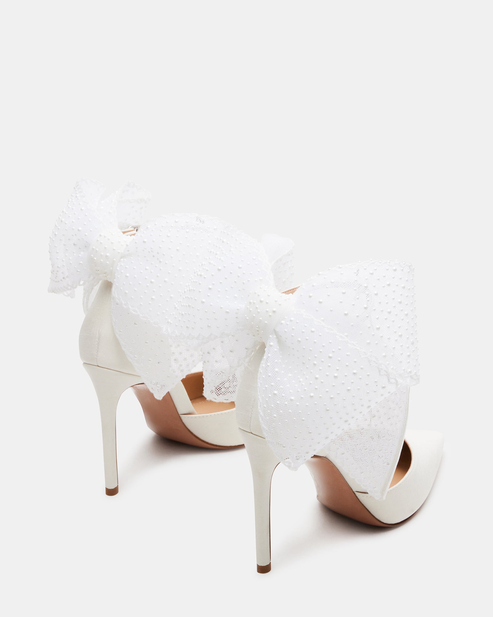 Side view of elegant pearl embellished white satin heels showcasing bow detail.