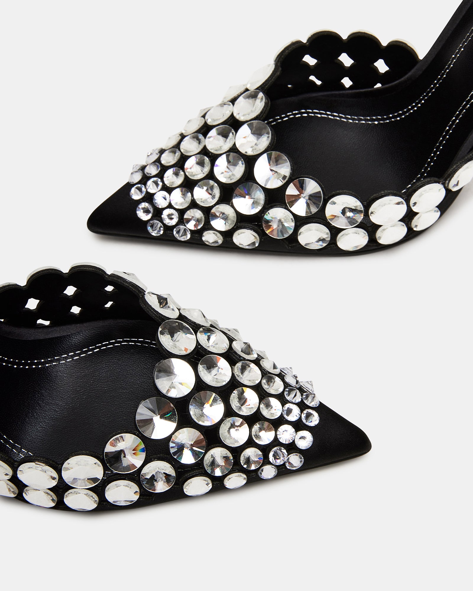 Detail shot of rhinestone heel on black high heels against evening backdrop