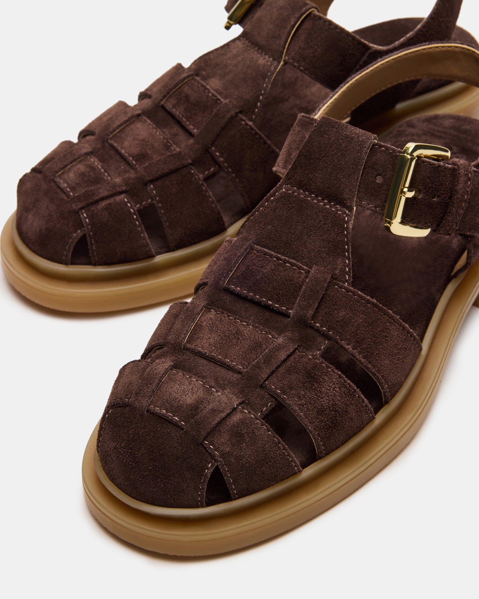 Brown suede sandals on a sunny beach, ideal for summer outings.