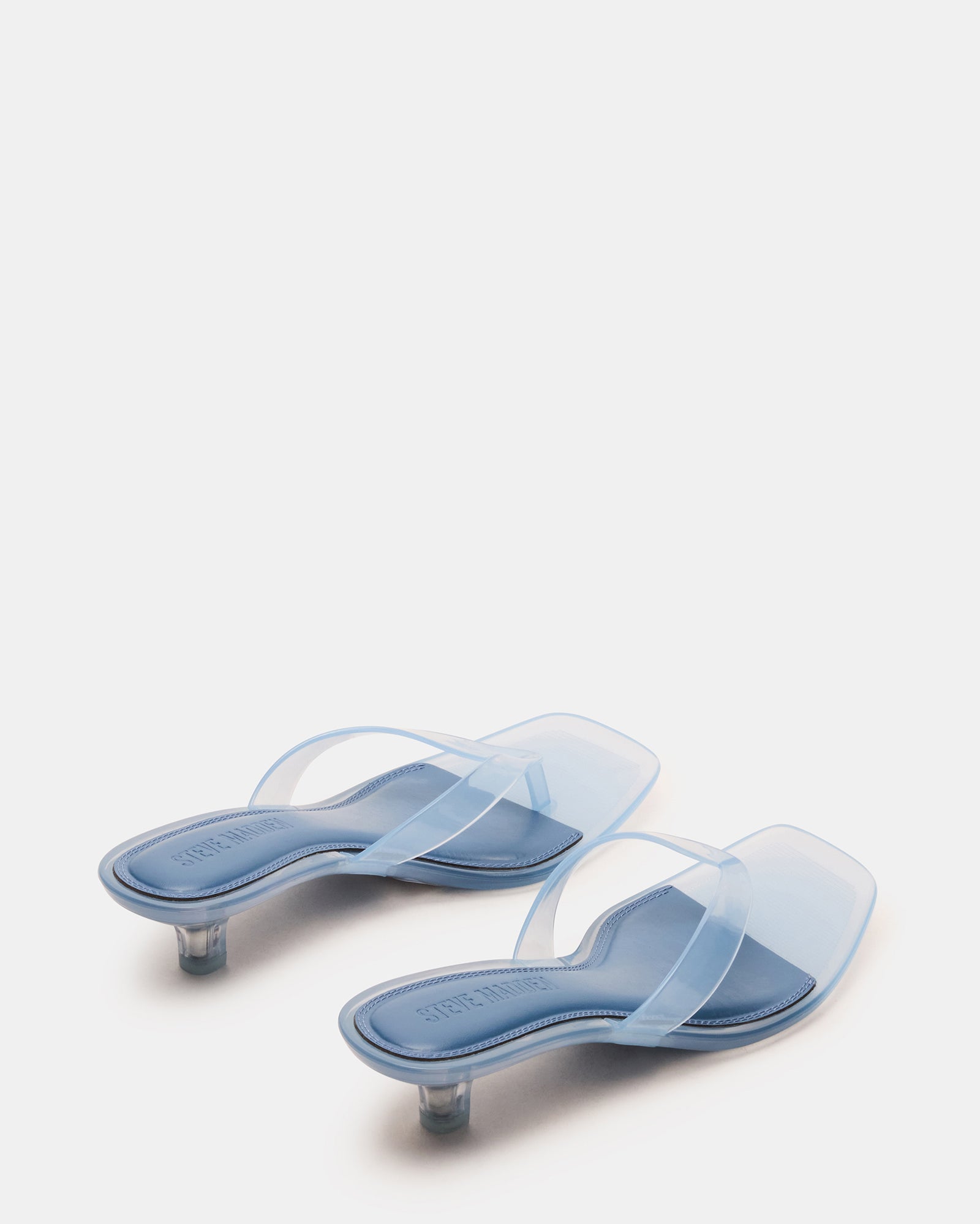 Close-up of the thong strap design on light blue kitten heel sandals.