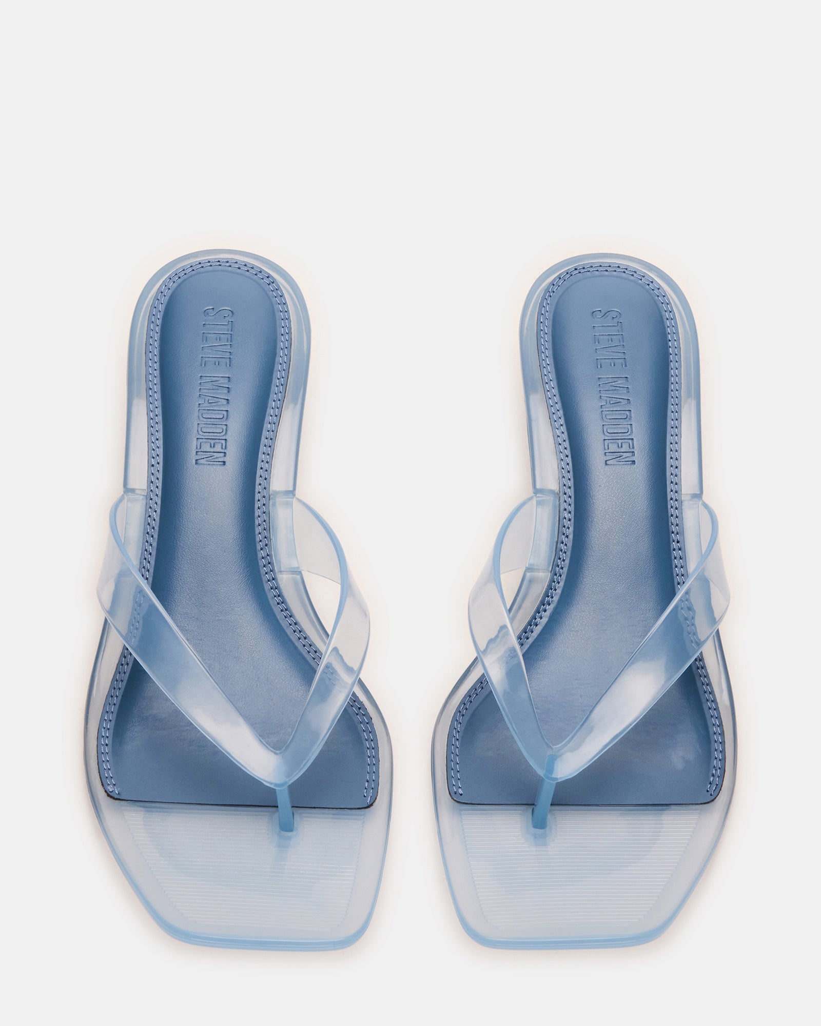 Elegant light blue kitten heel sandals displayed on a stylish surface.
