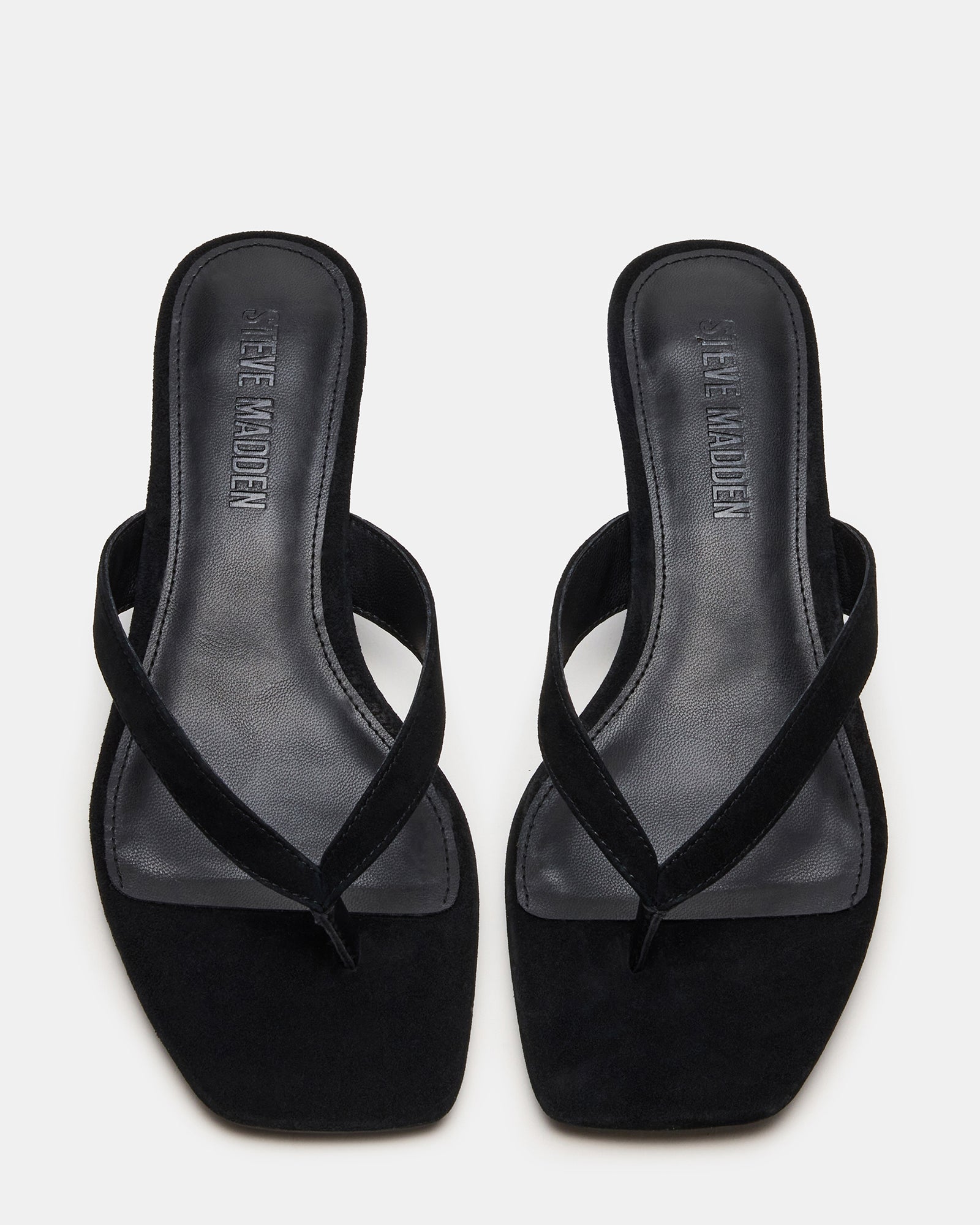 Close-up side view of black kitten heels showing sueded texture