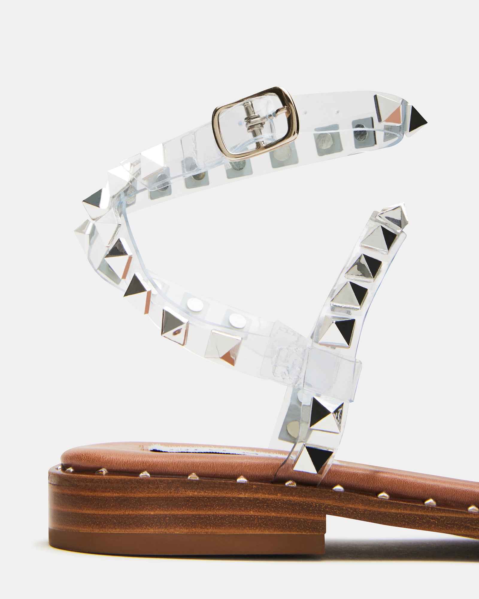 Brown strappy sandals displayed on a stylish outdoor patio.
