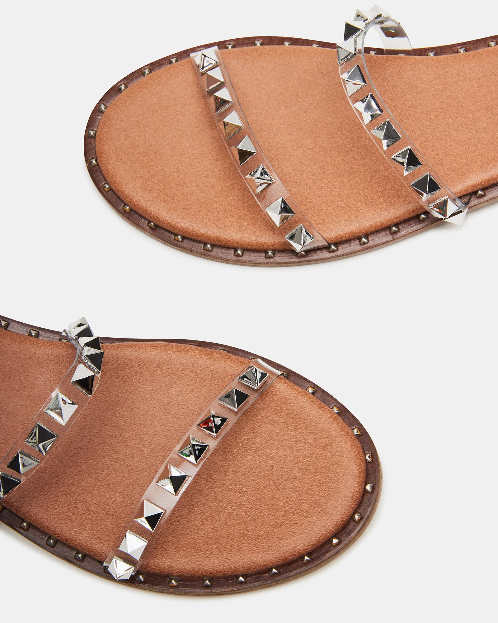 Close-up of chic black strappy sandals showcasing pyramid studs.