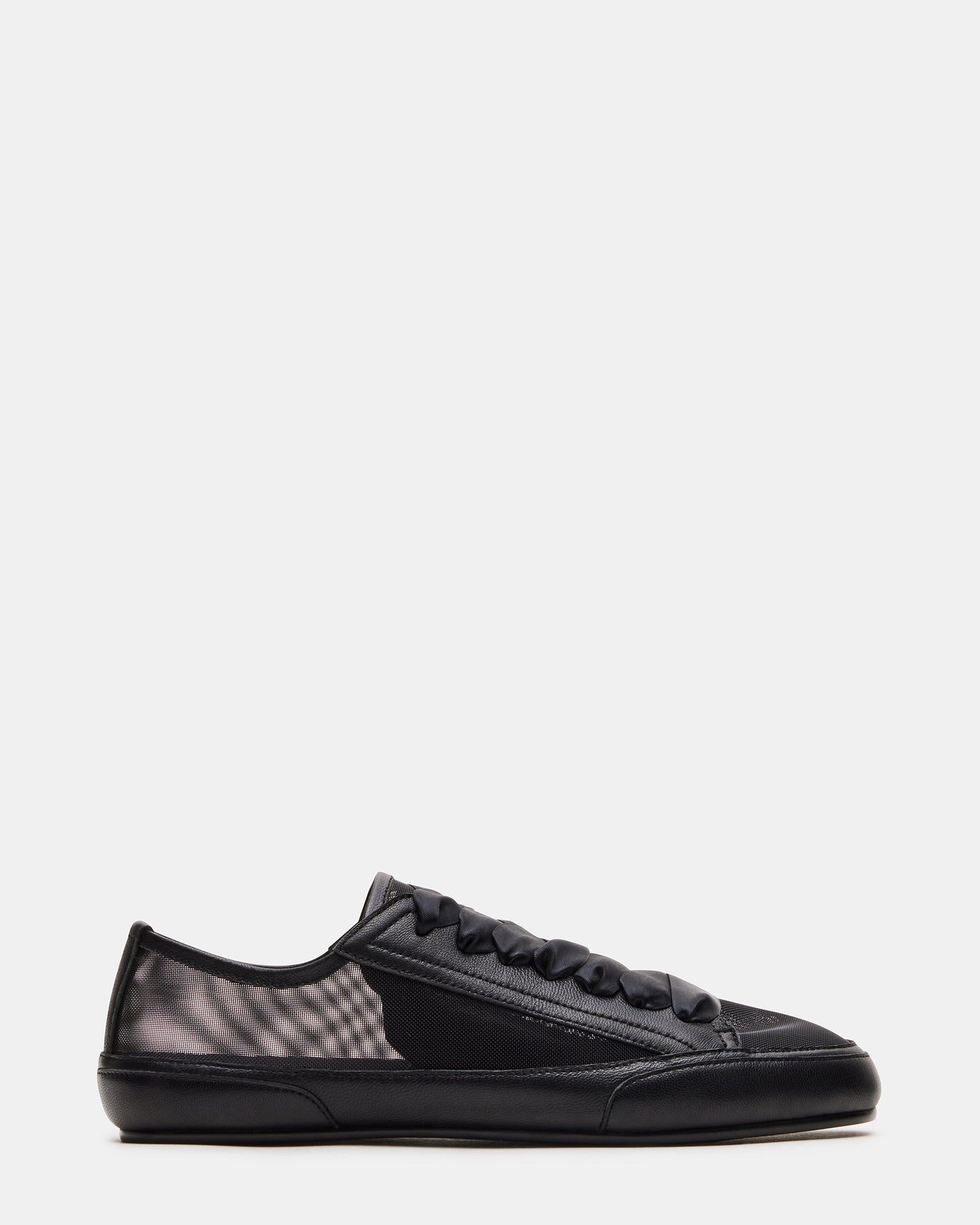 Side view of TREAD black leather sneakers featuring ribbon laces.